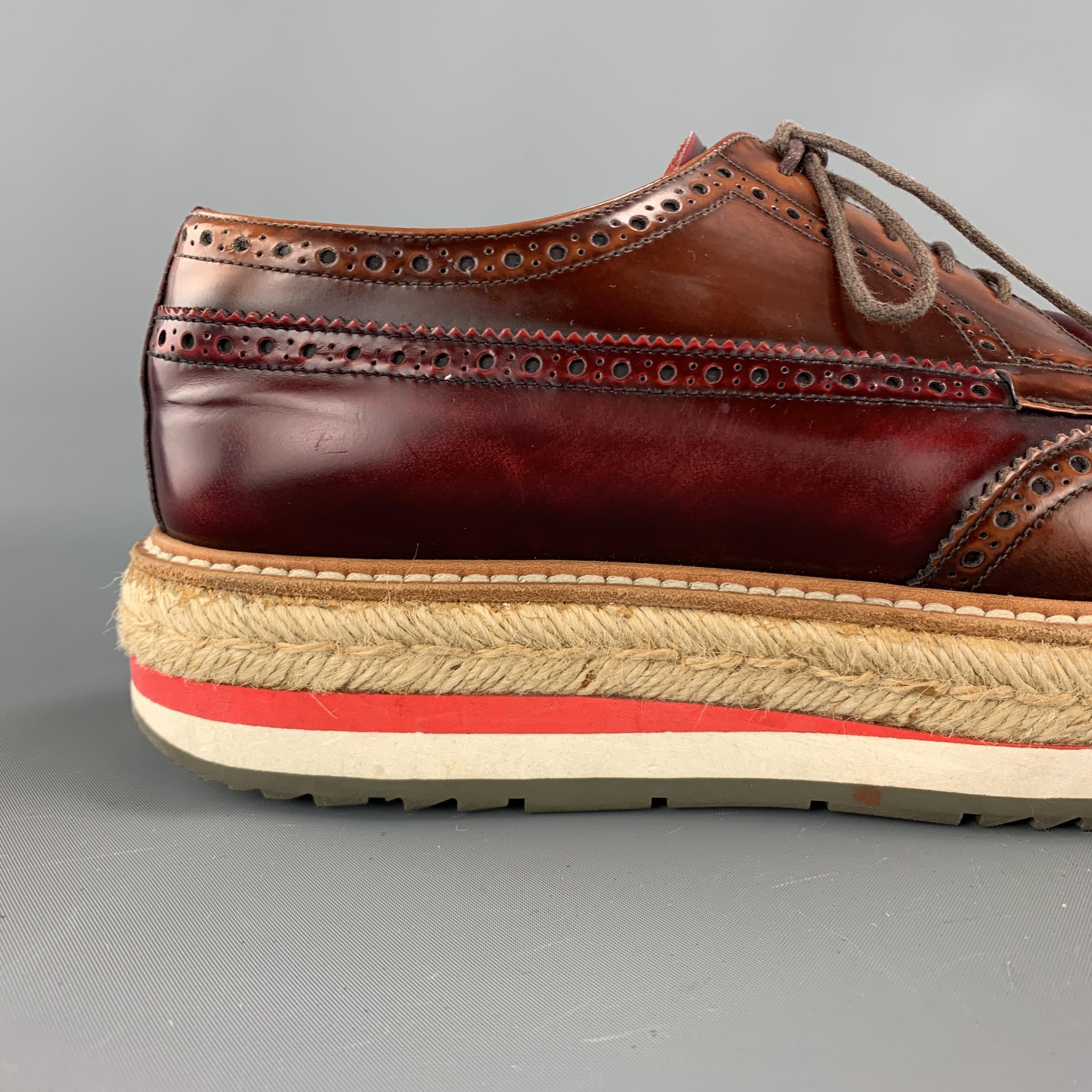 Iconic Spring Summer 2011 Collection PRADA brogues come in burgundy and tan brown color block antique style  leather and feature a wingtip, perforated brogue details, and thick braided espadrille sole. Made in Italy.

Excellent Pre-Owned