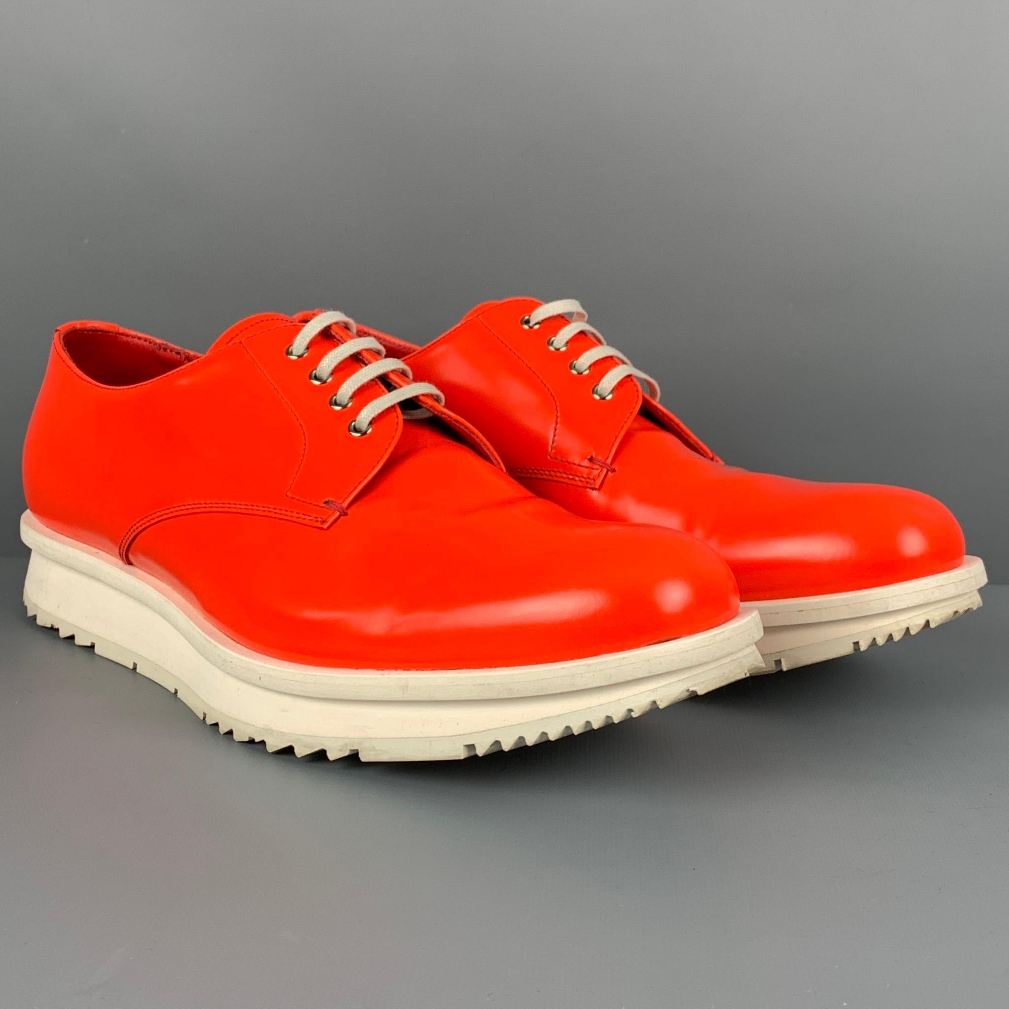 PRADA shoes comes in a orange & white leather featuring a square toe, rubber sole, and a lace up closure. Made in Italy. 

Very Good Pre-Owned Condition.
Marked: 2EE092 8

Outsole: 12 in. x 4 in. 