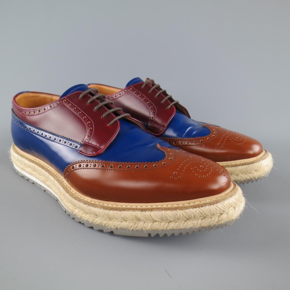 Iconic Spring Summer 2011 Collection PRADA brogues come in burgundy, navy blue, and tan color block leather and feature a wingtip, perforated brogue details, and thick braided espadrille sole.  With box. Made in Italy.
 
Excellent Pre-Owned