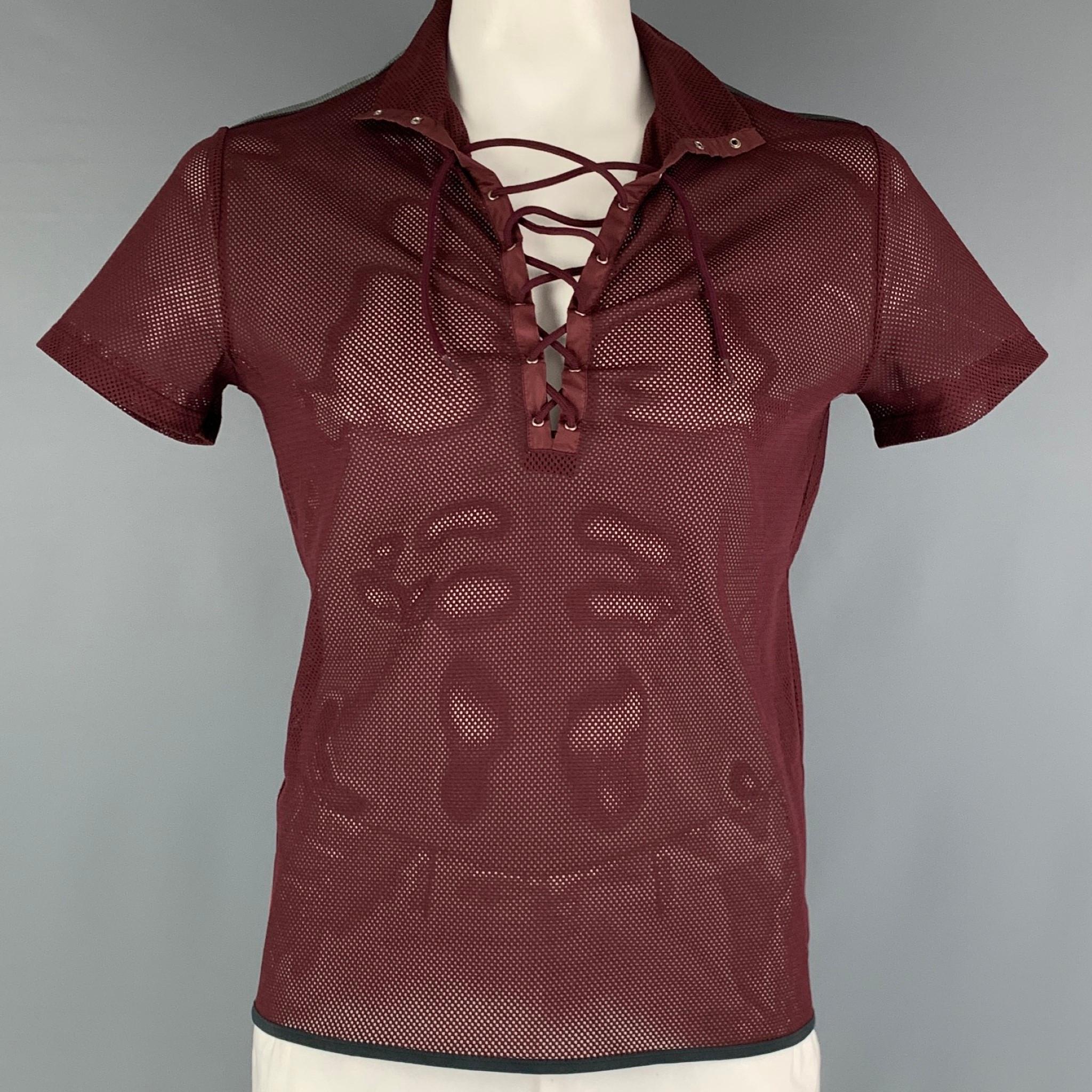 PRADA SPORT 90's T-shirt comes in a burgundy polyester mesh knit material featuring a lace up V-neck and a see through style. Made in Italy.

Very Good Pre-Owned Condition. Minor signs of wear.
Marked: L

Measurements:

Shoulder: 18 in.
Chest: 44
