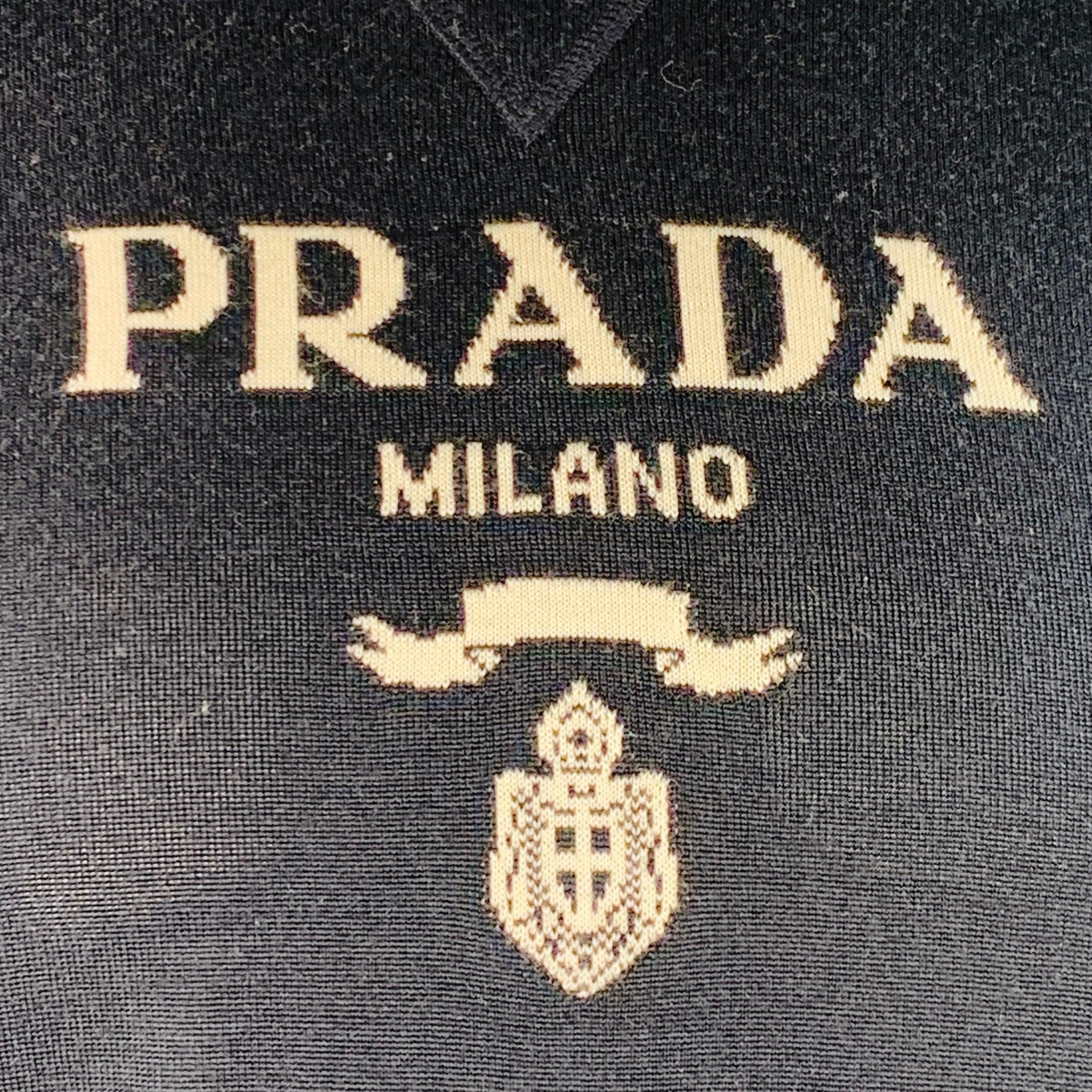 PRADA Pullover aus navyfarbenem Kaschmir-Wolljersey mit weißem Logo, kurzen Ärmeln und Rundhalsausschnitt. Made in Italy Ausgezeichneter Pre-Owned Zustand. 

Markiert:   IT 52 

Abmessungen: 
 
Schultern: 17 Zoll Brustumfang: 46 Zoll Ärmelumfang: 10