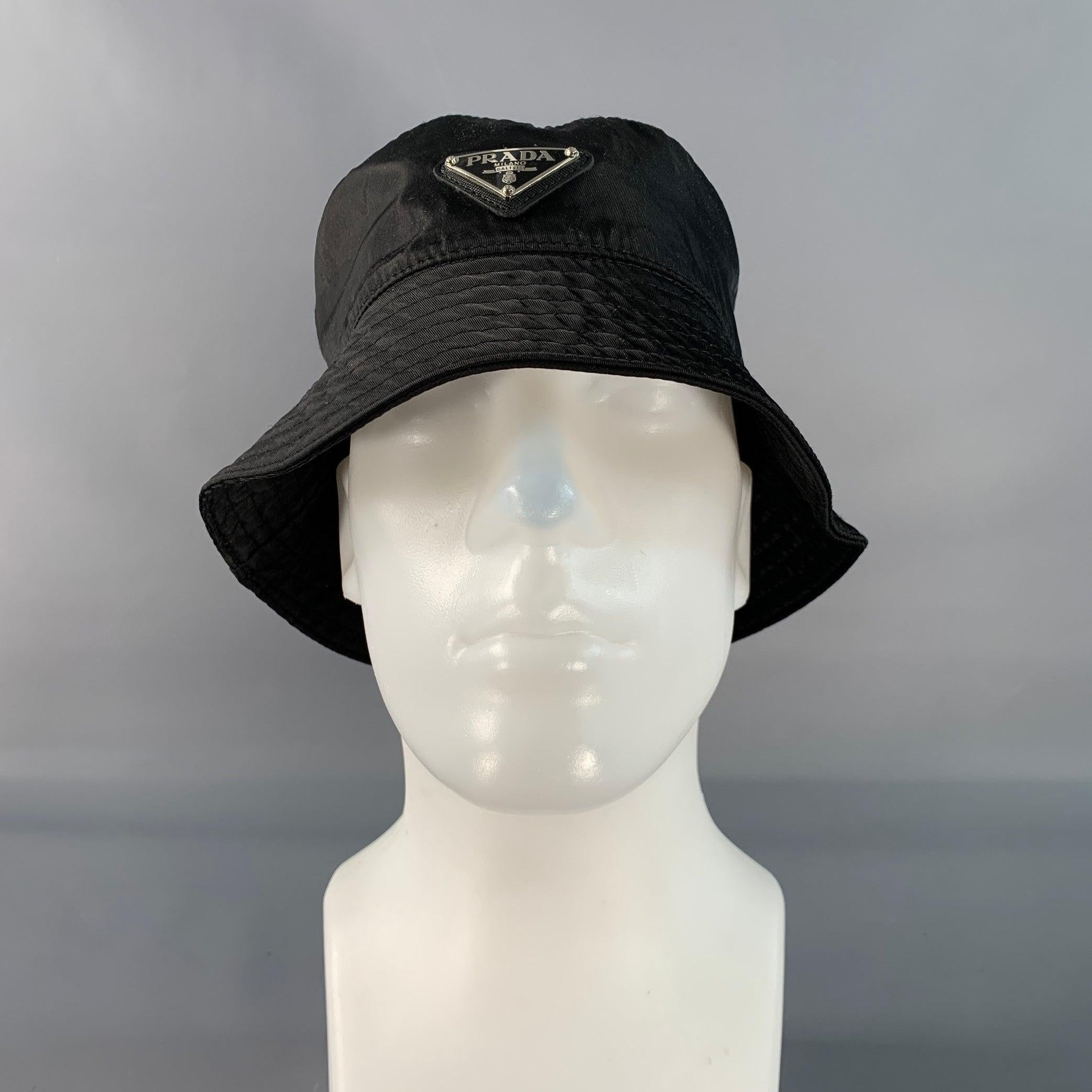 Cappello di Prada in tessuto poliestere nero con stile a secchiello e logo Prada. Made in Italy. Eccellente condizione di usato. 

Contrassegnato:   M 

Misure: 
  Apertura: 21,5 pollici Tesa: 2,25 pollici Altezza: 3,5 pollici 
 
  
  
