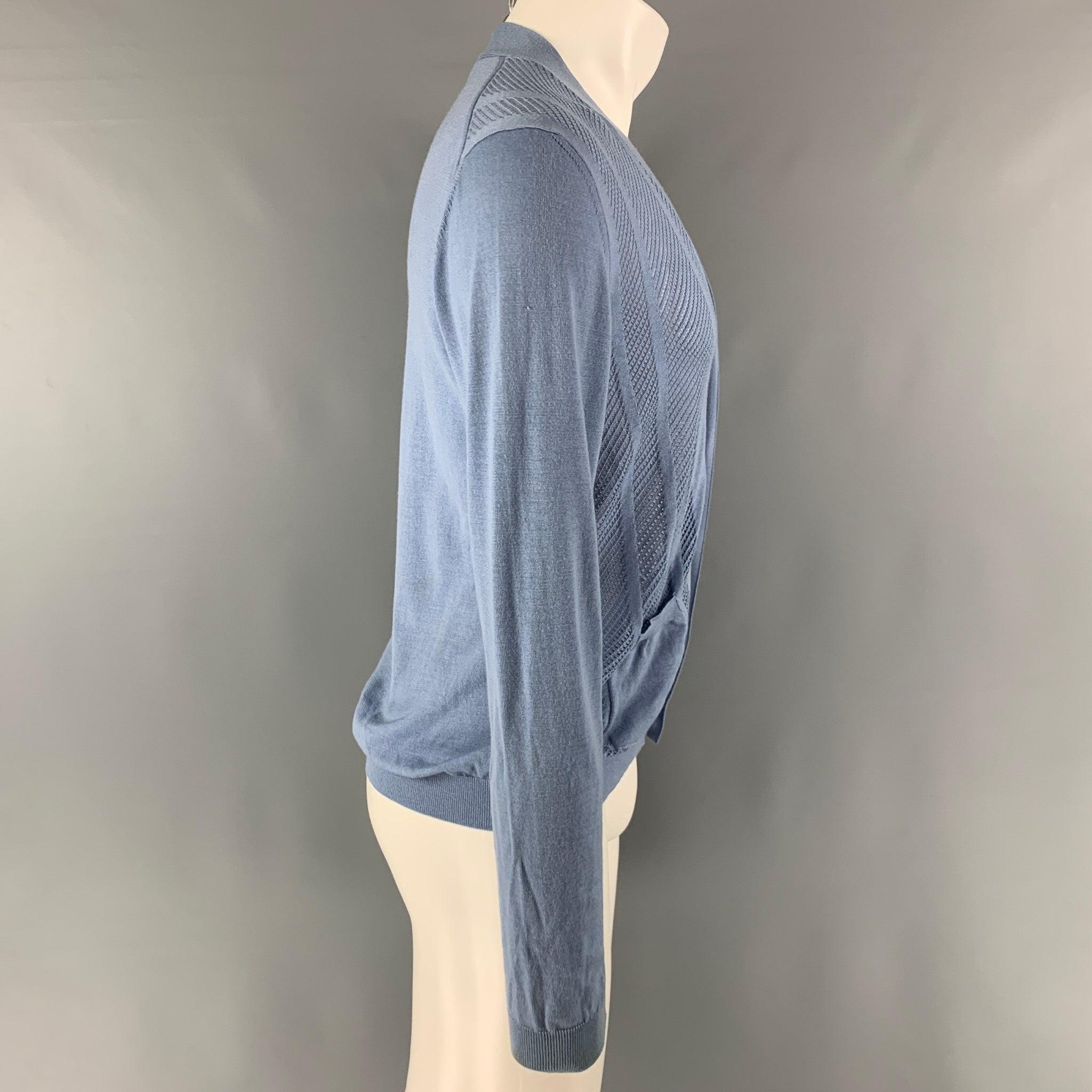 PRADA cardigan comes in a blue wool knit material featuring an open knit details at front, front pockets, and V-neck. Made in Italy.Good Pre-Owned Condition. Several marks, and moderate sign of wear. As -Is.  

Marked:   50 

Measurements: 
