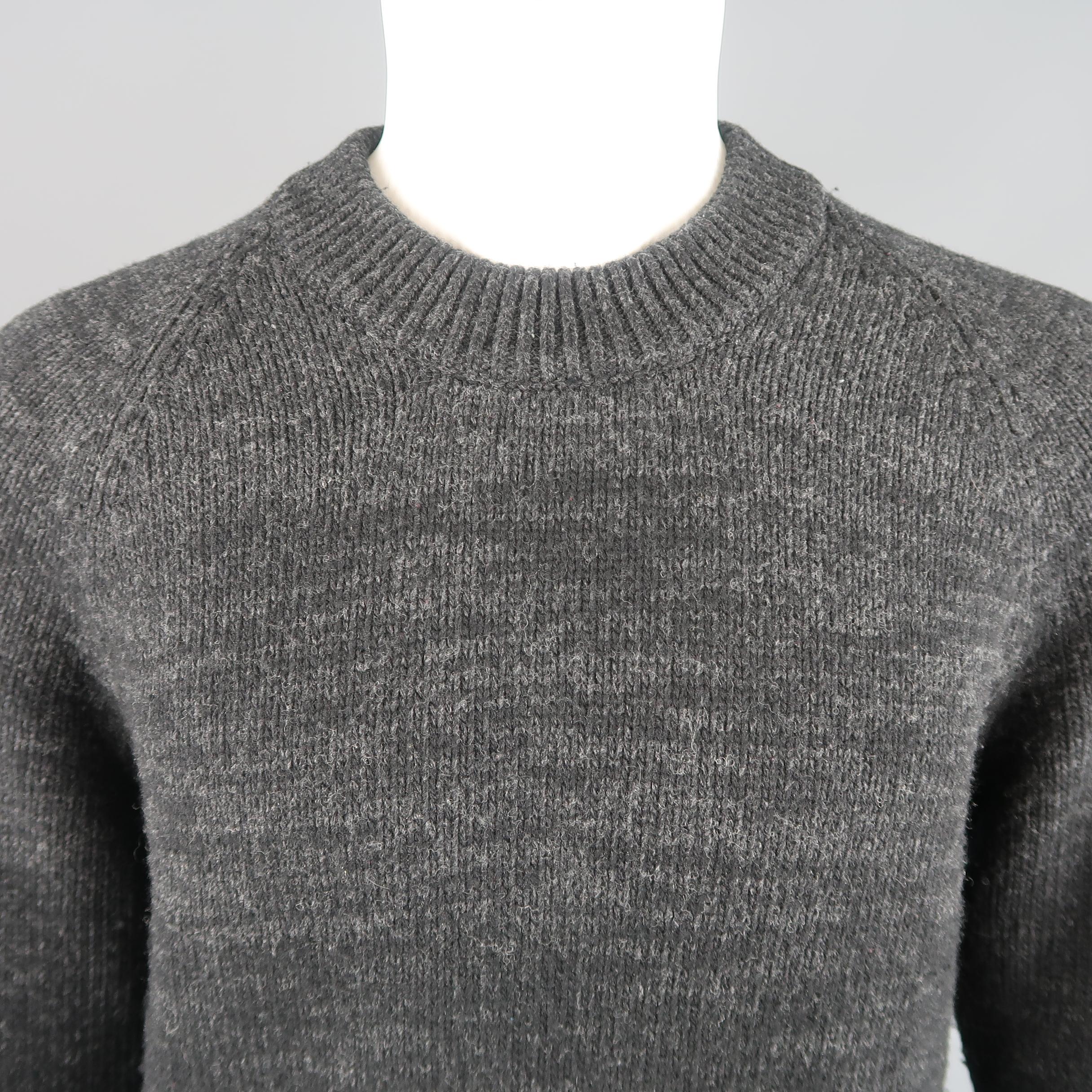 PRADA pullover sweater comes in black wool cashmere blend knit with an all over gray heathered ombre effect, ribbed crew neck, raglan sleeves, and thick ribbed waistband and cuffs. Made in Italy.
 
Excellent Pre-Owned Condition.
Marked: IT 50
