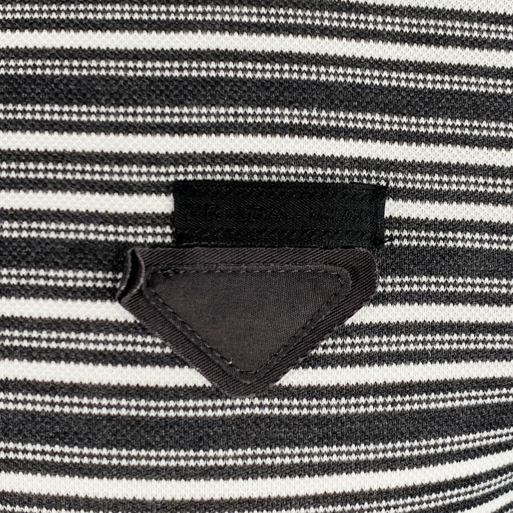 Polo PRADA
en piqué de coton gris anthracite et blanc, avec un motif à rayures, un logo triangulaire et une demi-patte boutonnée. Fabriqué en Italie. Excellent état.  

Marqué :   M 

Mesures : 
 
Épaule : 17 pouces Poitrine : 40 pouces Manches : 9