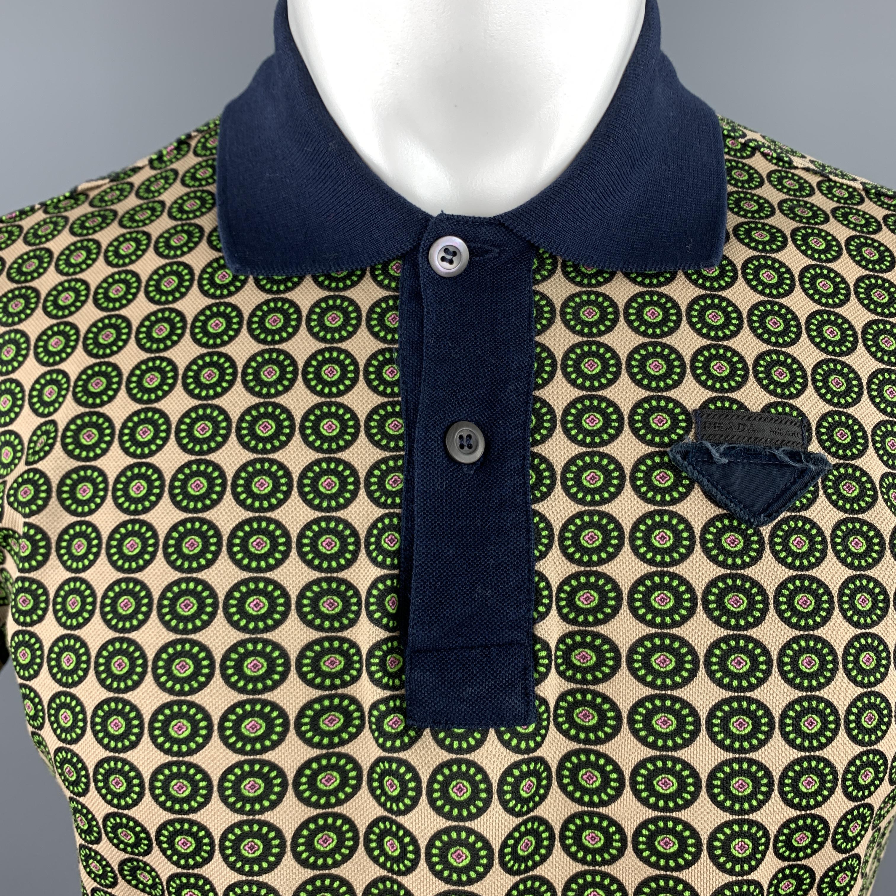 PRADA polo shirt comes in beige cotton pique with an al over black and green retro print, navy collar, and triangle logo patch.

Excellent Pre-Owned Condition.
Marked: M

Measurements:

Shoulder: 18 in.
Chest: 44 in.
Sleeve: 7 in.
Length: 23.5 in.