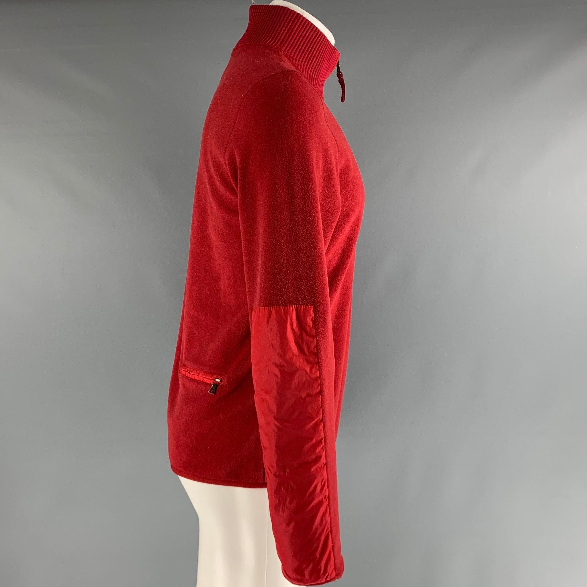 PRADA SPORT Pullover aus rotem Polyester-Fleece mit Rückentasche und 1/4-Reißverschluss. Sehr guter, gebrauchter Zustand. 

Markiert:   M 

Abmessungen: 
 
Schultern: 17,5 Zoll Brustumfang: 40 Zoll Ärmelumfang: 26 Zoll Länge: 27 Zoll  
 
  
  
