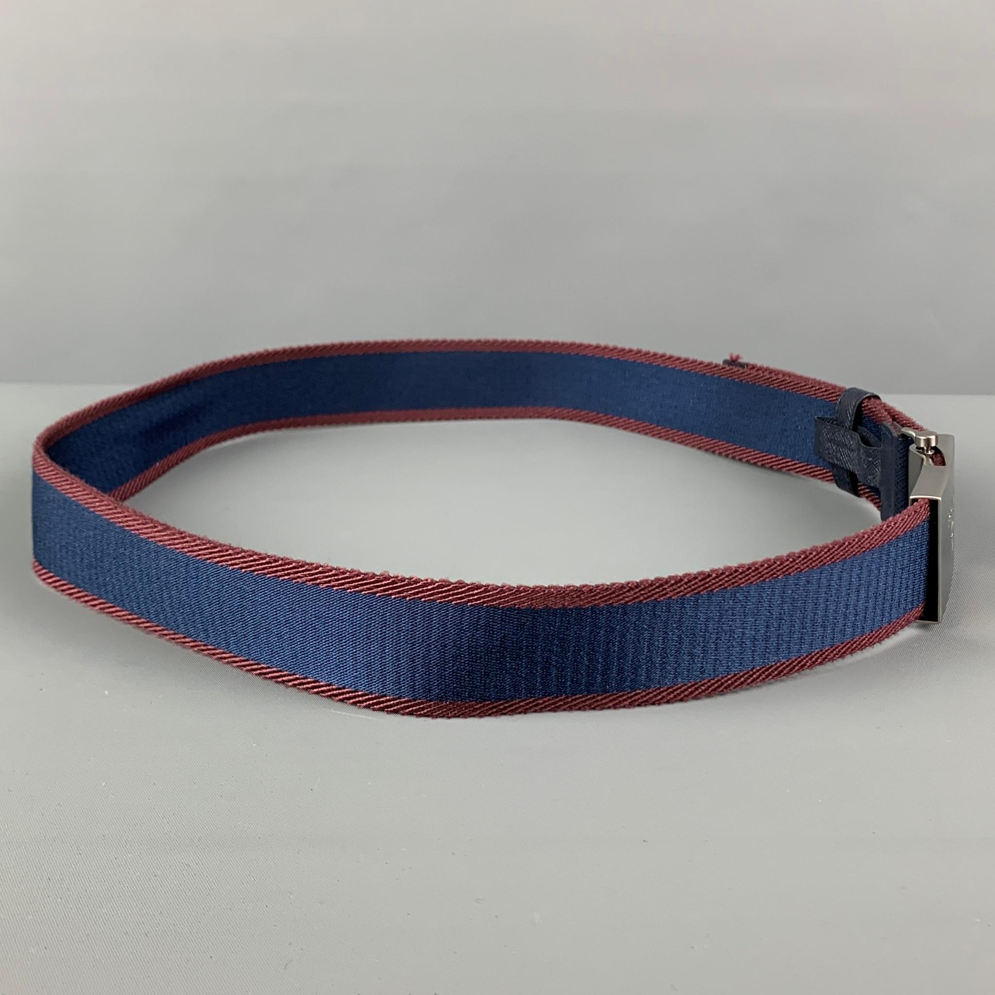 PRADA belt comes in a navy & burgund stripe ribbon material featuring a silver tone buckle closure. 

Very Good Pre-Owned Condition.
Marked: 90/36

Length: 42 in.
Width: 1.5 in.
Buckle: 2.25 in. 