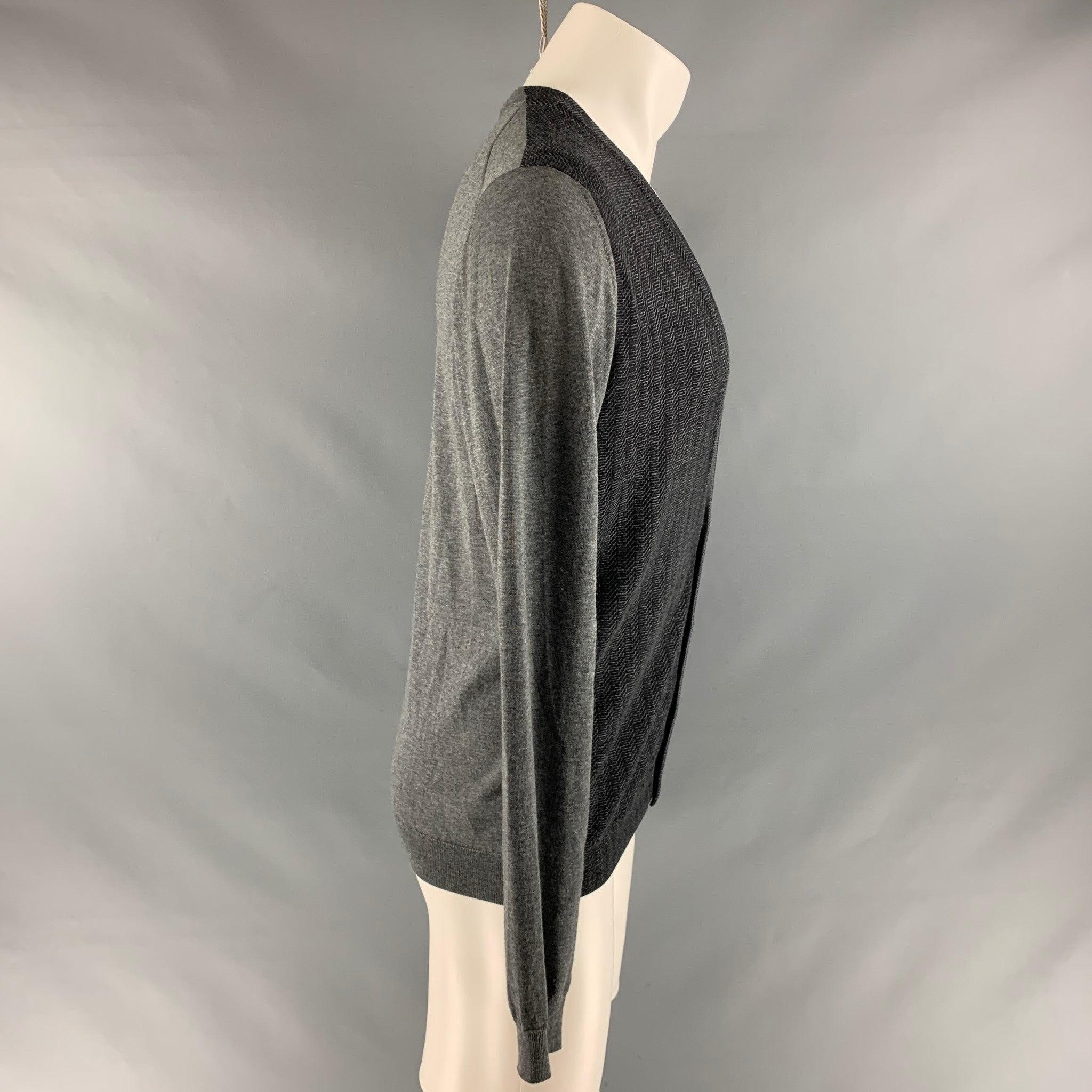 PRADA cardigan comes in a black and grey knitted wool featuring a ribbed panel and a v-neck, and button closure. Made in Italy. Excellent Pre-Owned Condition. 

Marked:   48 

Measurements: 
 
Shoulder: 17.5 inches Chest: 42 inches Sleeve: 26.5