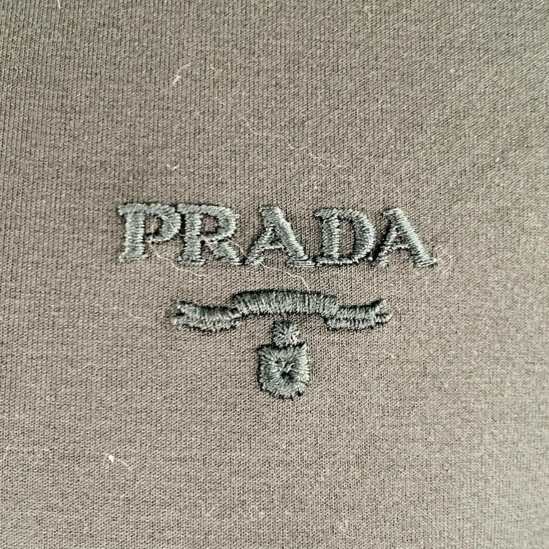 PRADA t-shirt
in a forest green cotton stretch blend featuring embroidered logo, short sleeves, and crew neck. Made in Italy.Excellent Pre-Owned Condition. 

Marked:   XL 

Measurements: 
 
Shoulder: 18.5 inches Chest: 42 inches Sleeve: 8 inches