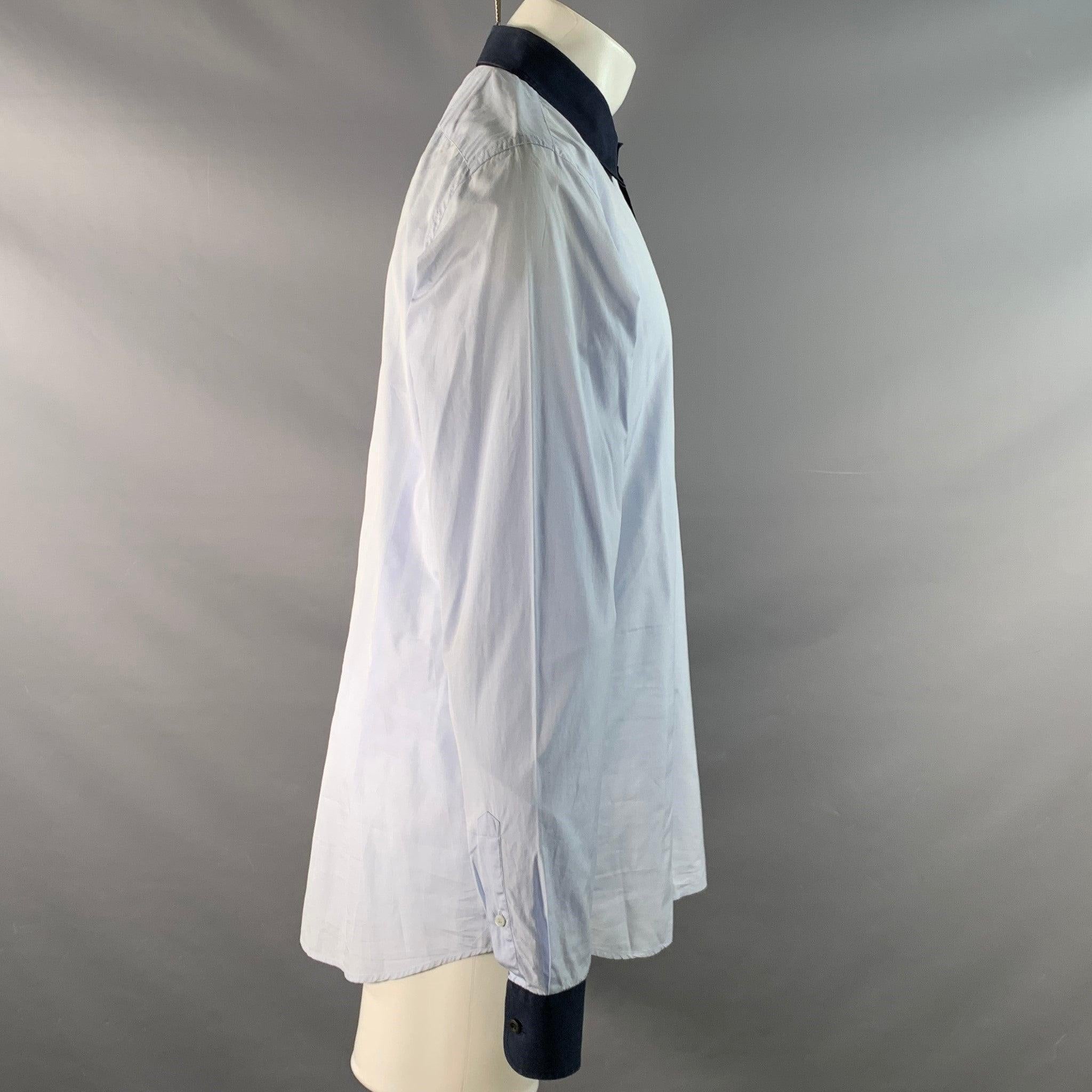 Camicia abbottonata di Prada in cotone blu chiaro con colletto a contrasto, colletto a punta, chiusura a 3/4 con bottoni. Made in Italy. Eccellente condizione di usato. 

Contrassegnato:   44 17 1/2 

Misure: 
 
Spalla: 18,5 pollici Petto: 49