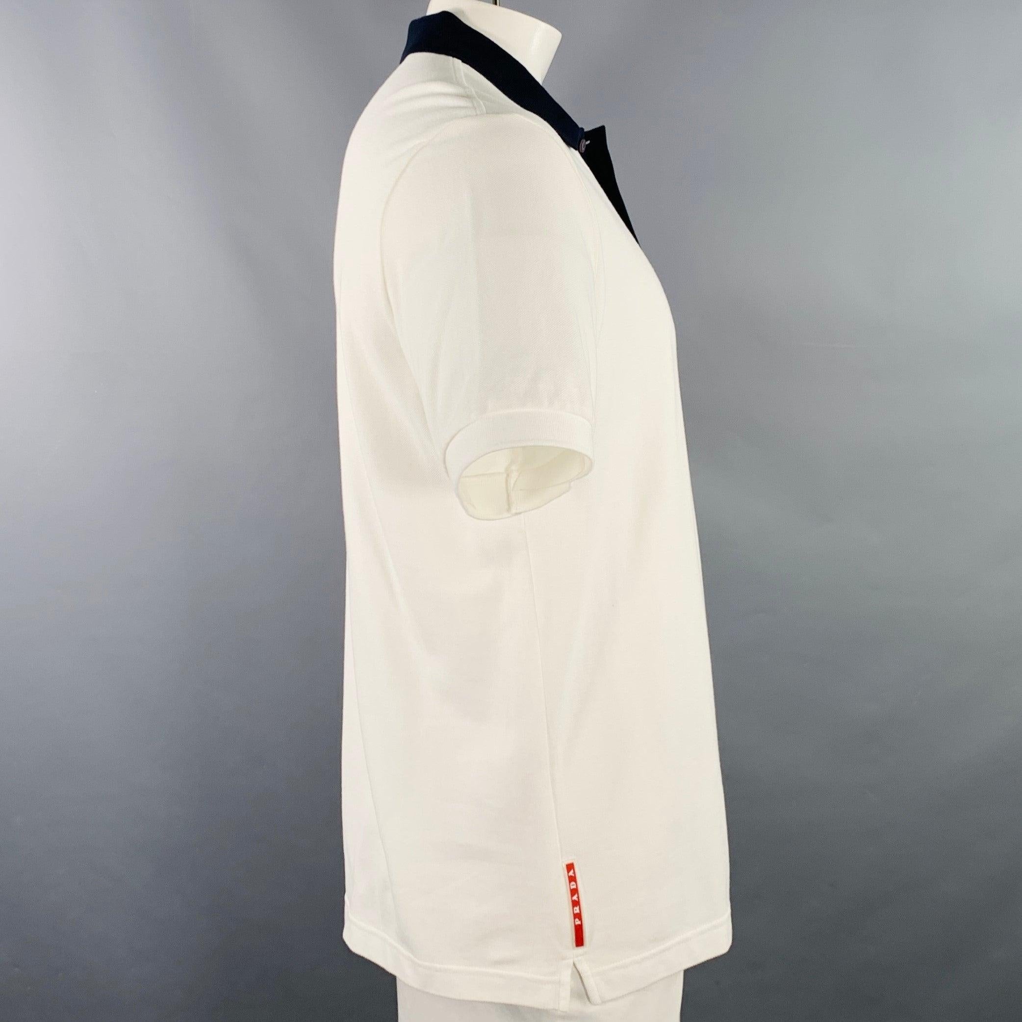 PRADA polo
in a white cotton pique featuring contrasting navy trim, and half placket button closure. Excellent Pre-Owned Condition. 

Marked:   XXL 

Measurements: 
 
Shoulder: 17.5 inches Chest: 42 inches Sleeve: 10 inches Length: 29 inches 
  
 