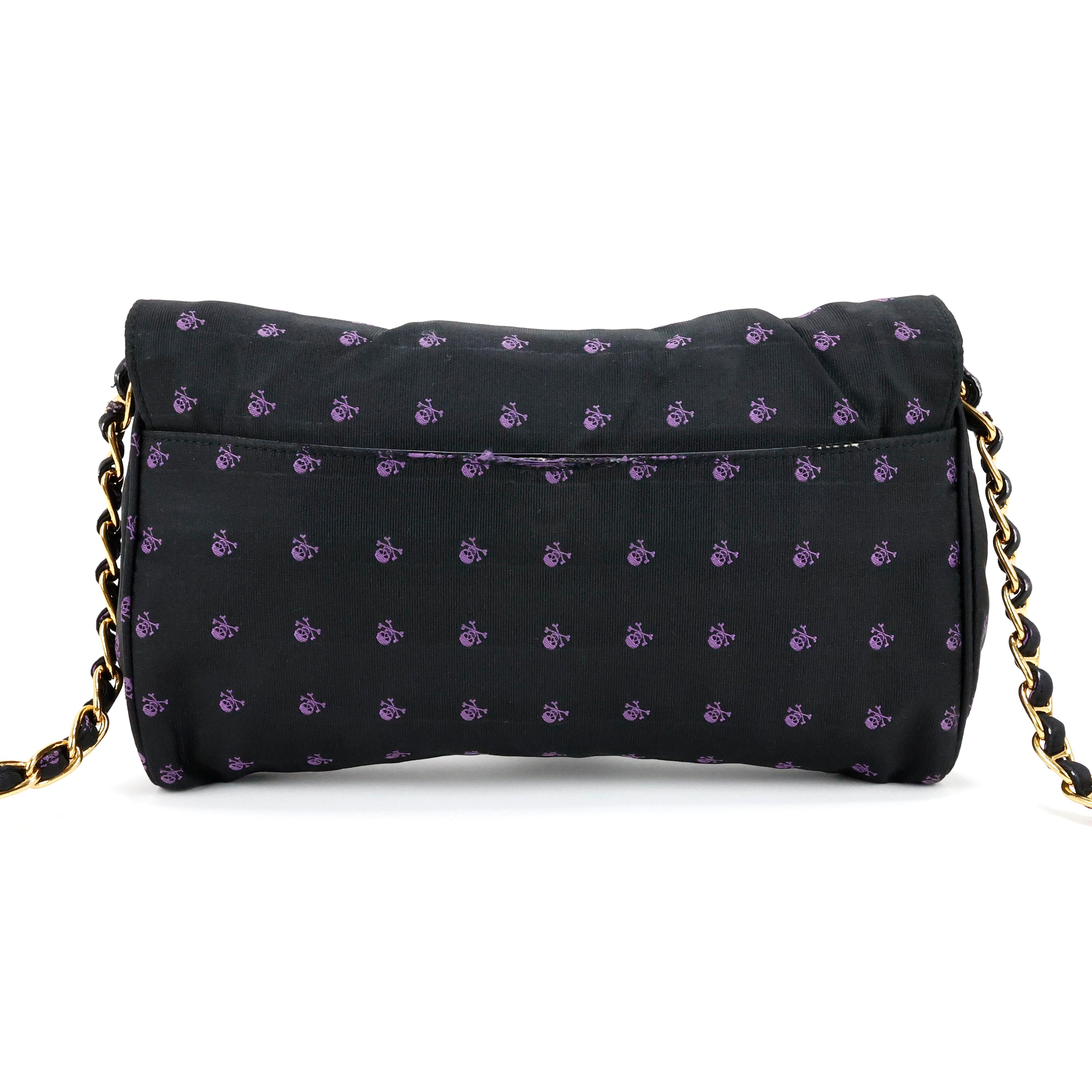Prada crossbody bag in black tessuto with purple skull pattern, chain handle, gold hardware.


Condition:
Good.


Packing/accessories:
Dustbag, authenticity card.


Measurements:
25cm x 15cm x 4cm