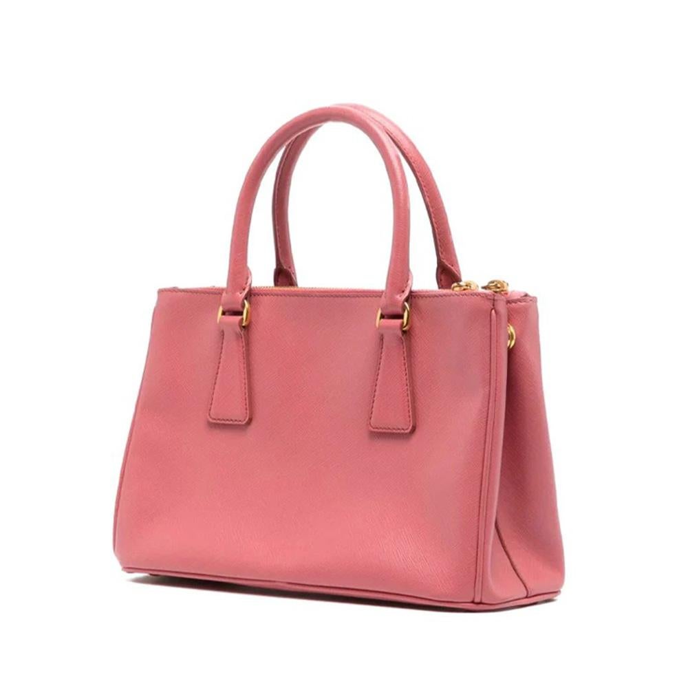 Crafted from Saffiano leather, the Small Galleria bag from Prada is designed with the modern woman in mind. Featuring a detachable and adjustable 115 cm shoulder strap for maximum flexibility, two external zipper pockets for convenient access, and