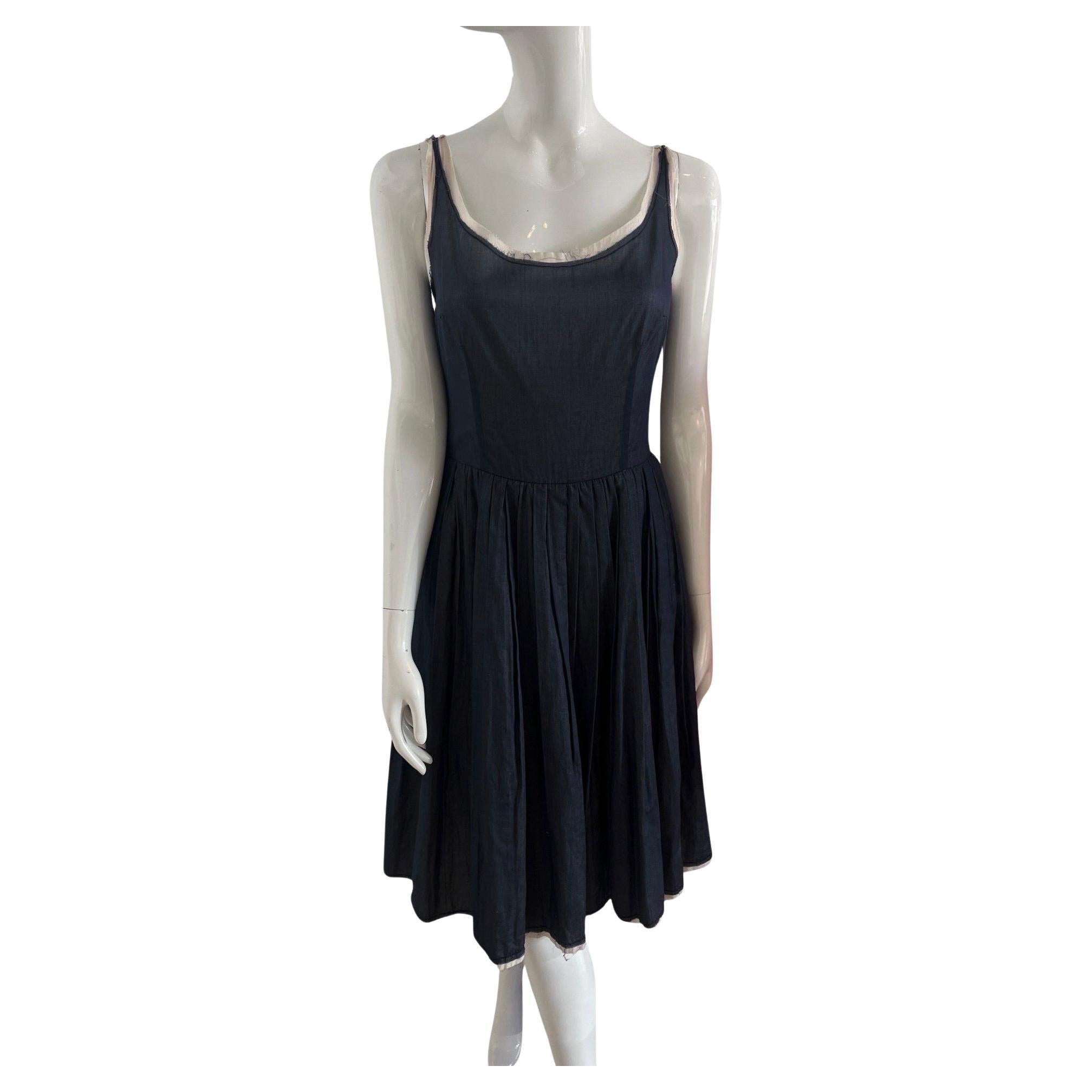 Early Y2K Prada perfect for an Italian summer.  This dress is two layers of light cotton.  The inside layer is an ecru color and the outside is a navy chambray.  The hems are unfinished.  The dress has a round neck, fitted at the waist with a zip up