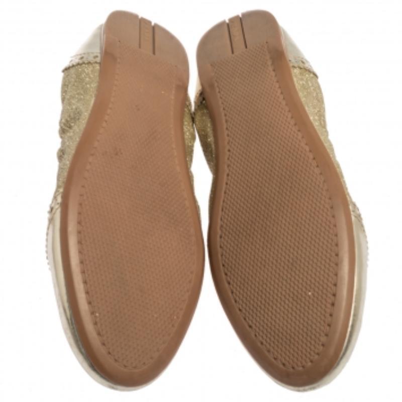 Beautiful and unique, these ballet flats from Prada Sport are crafted from gold glitter fabric and patent leather and styled with round toes and brogue details. They are endowed with comfortable leather-lined insoles and complete with durable rubber