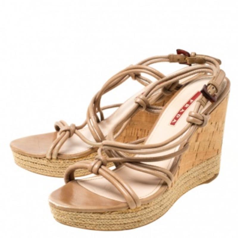 Portez ces fabuleuses sandales de Prada Sport et sortez avec style. Elles sont dotées de brides en cuir, de fermetures à boucle et de semelles compensées en liège avec bordure en espadrille. Ces sandales beiges sont un article de mode haut de gamme