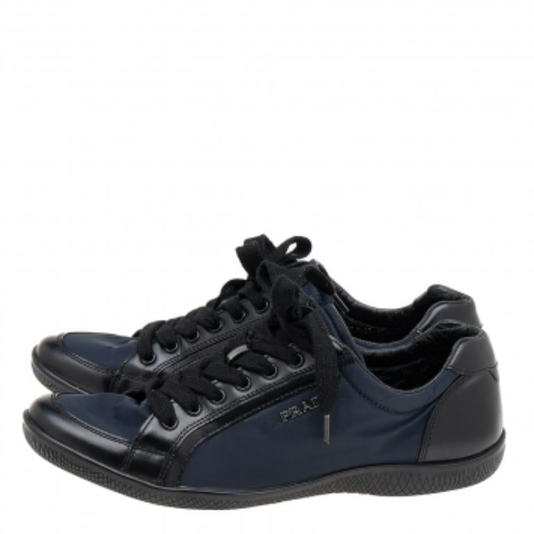 Prada Sport brings you these super stylish sneakers to elevate your appearance! They are crafted using black and navy-blue nylon and leather into a sturdy low-top silhouette. They exhibit lace-up fastenings and silver-tone hardware. Walk with style