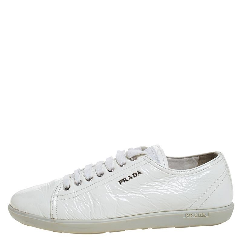 These Prada Sport low top sneakers are the embodiment of style and comfort. Rendered in a classic white color and crafted with patent leather, these impressive sneakers are accented with lace-ups and the brand label on the quarters. They are also