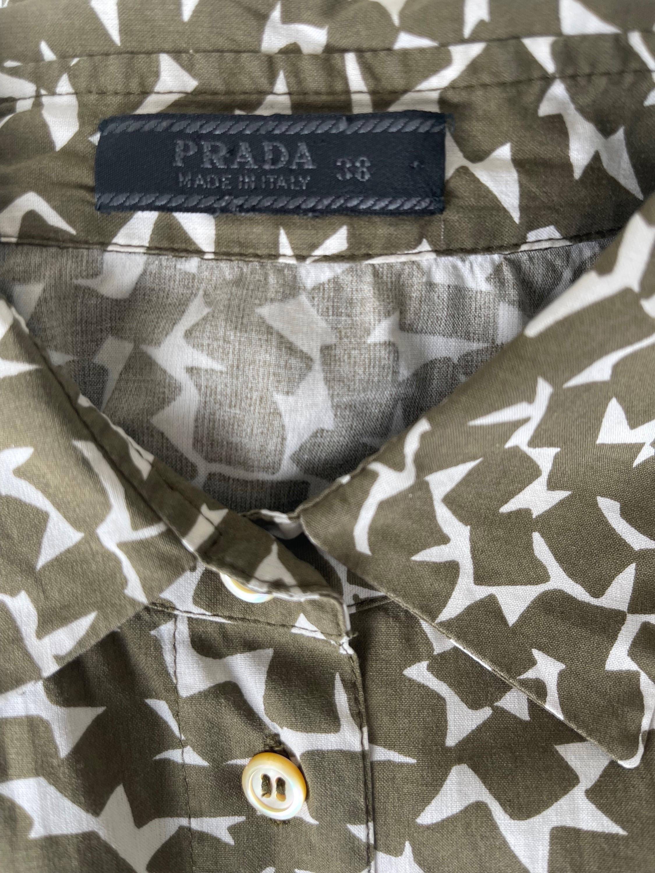 Chic PRADA Spring 2002 hunter green and white 3/4 sleeves button up blouse ! Features abstract prints with the Prada logo printed between throughout. Pair with jeans, shorts, trousers or a skirt.
In great condition 
Made in Italy
Marked Size