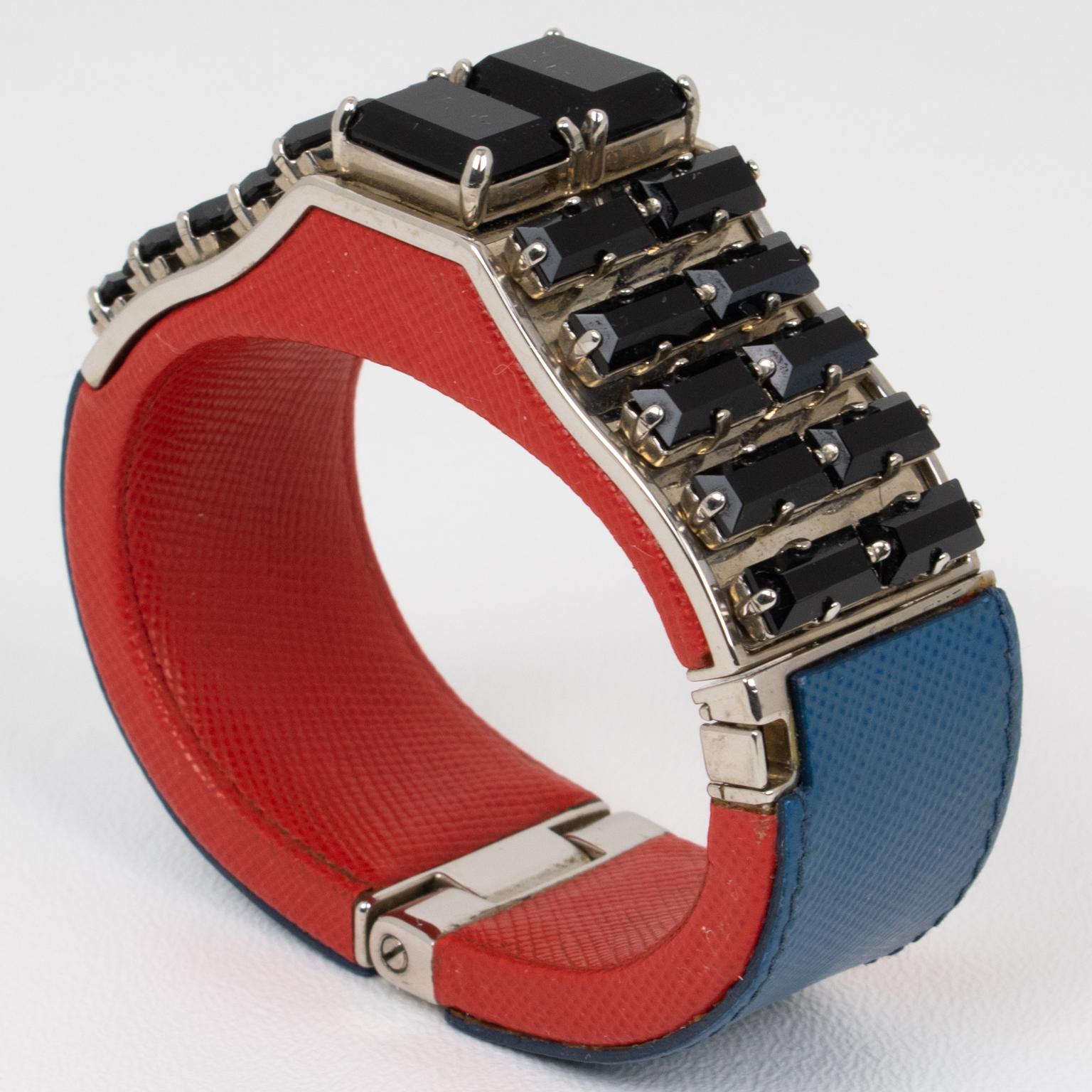 Prada, Italie, a conçu cet extraordinaire bracelet clamper pour ses défilés de prêt-à-porter et de villégiature printemps-été 2014. Cet accessoire saisissant combine l'allure luxueuse du cuir Saffiano bleu et rouge avec les accents mystérieux des