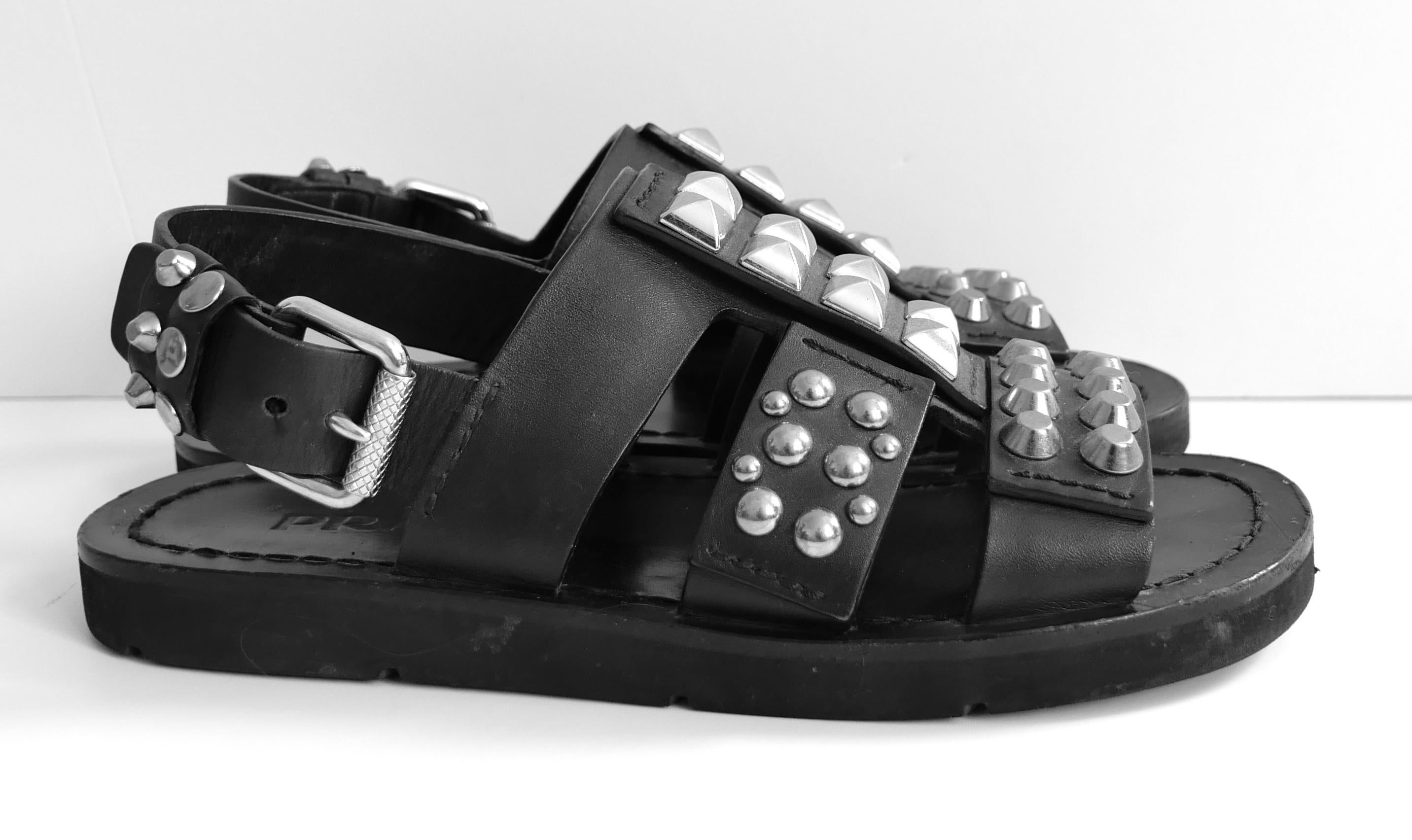 Super coole Prada Nieten-Sandalen aus der Frühjahrskollektion 2018 - Look 2 auf dem Laufsteg kommen. Weniger als eine Handvoll Mal getragen. Aus dickem schwarzem Leder mit klobigen silberfarbenen Nieten, großer Schnalle und klobigen