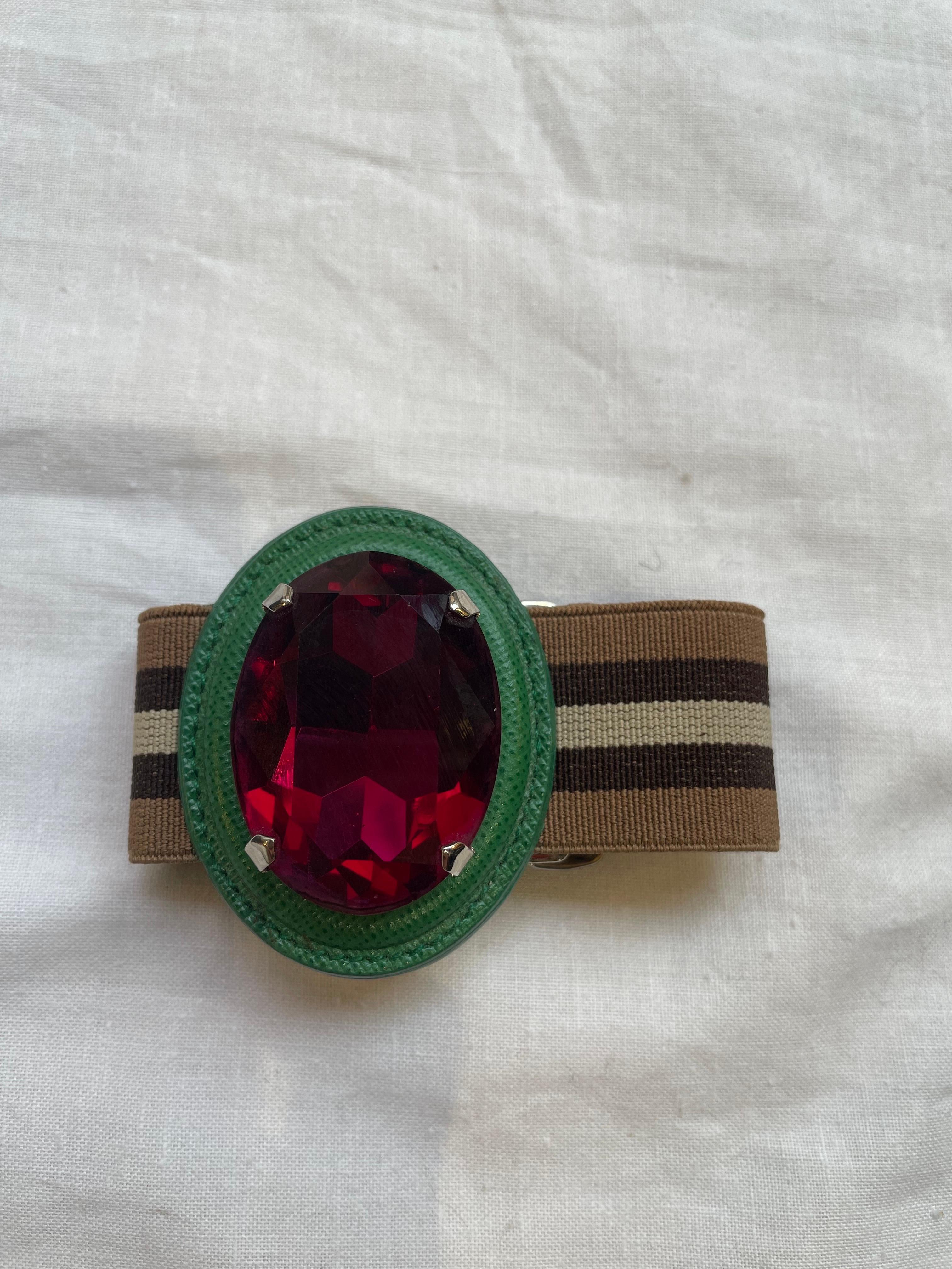 Prada spring summer 2014 bracelet, collection inspired by the high jewelery of the 1940s.
Elastic in shades of brown, details in green saffiano leather and fuchsia stone. 
It shows some signs of use. 
With original dust.
3.5cm high elastic 
Central