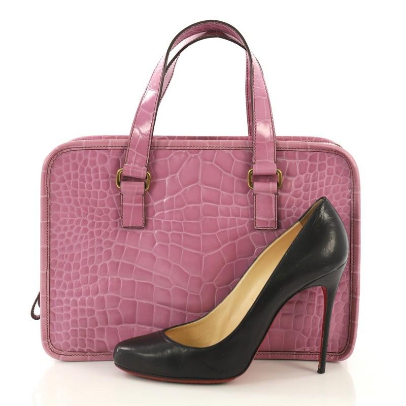 This Prada St. Cocco Lucido Bauletto Handle Bag Crocodile Embossed Leather, crafted in purple crocodile embossed leather, features dual-flat handles, iconic Prada logo, and aged gold-tone hardware. Its two main compartments showcases a zip closure
