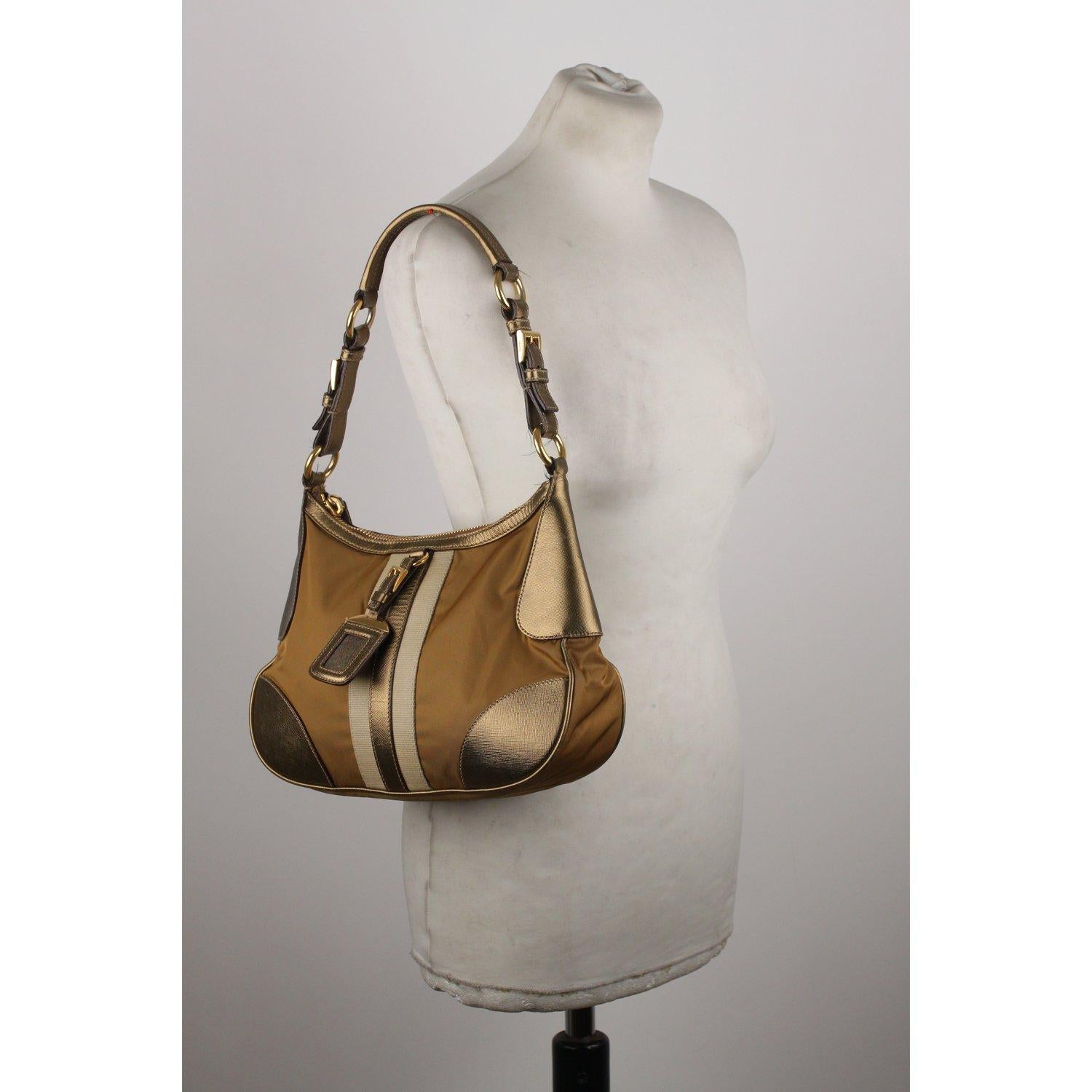 MATERIAL: Nylon COLOR: Gold MODEL: Hobo GENDER: Women SIZE: Medium Condition CONDITION DETAILS: B :GOOD CONDITION - Some light wear of use - Some wear of use on corners and on leather trim, some spots on canvas on the front Measurements
