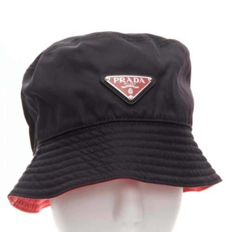 PRADA Symbole black metal triangle logo red inside nylon bucket hat M
Reference: CAWG/A00293
Brand: Prada
Designer: Miuccia Prada
Material: Nylon
Color: Black, Red
Pattern: Solid
Closure: Pullover
Lining: Red Cotton
Made in: