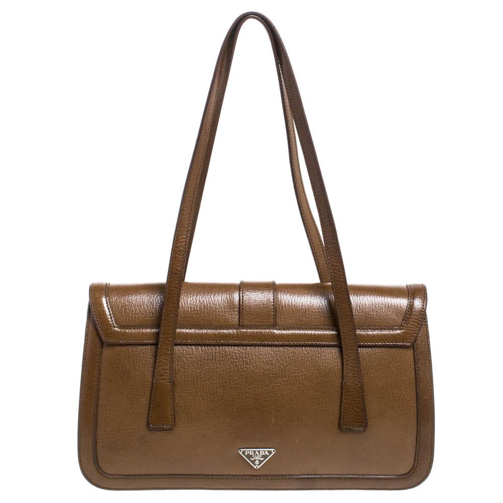 A chic bag for you to step out in style and win compliments! This tan bag from Prada comes crafted from leather and features a front silver-tone buckle detailed strap. It has dual shoulder straps and opens to a spacious nylon-lined interior that can