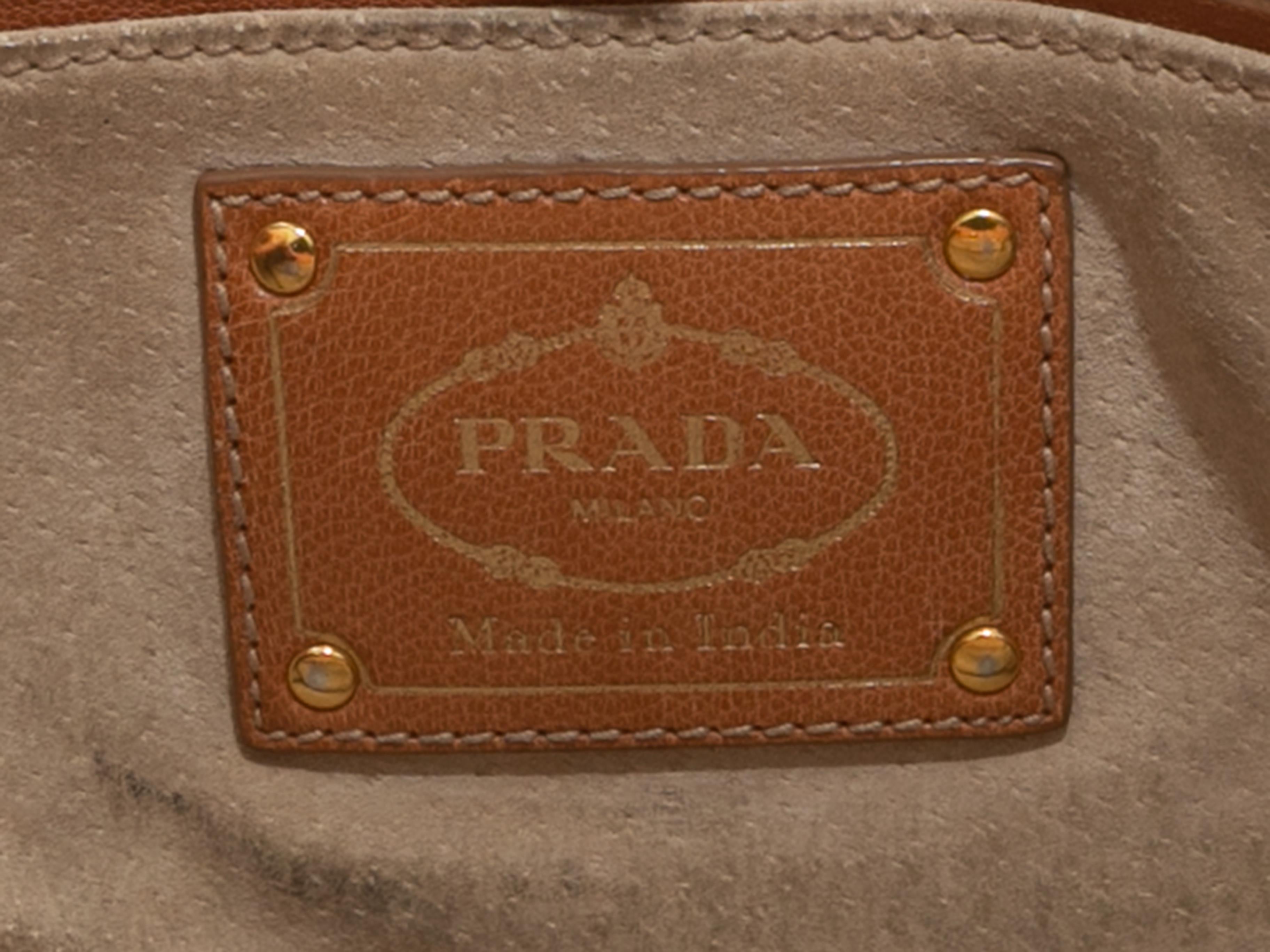 Product Details: Tan Prada Madras Woven Tote Bag. The Madras Bag features a woven leather body, gold-tone hardware, dual rolled top handles, optional flat shoulder strap, and a magnetic closure at the top. 13