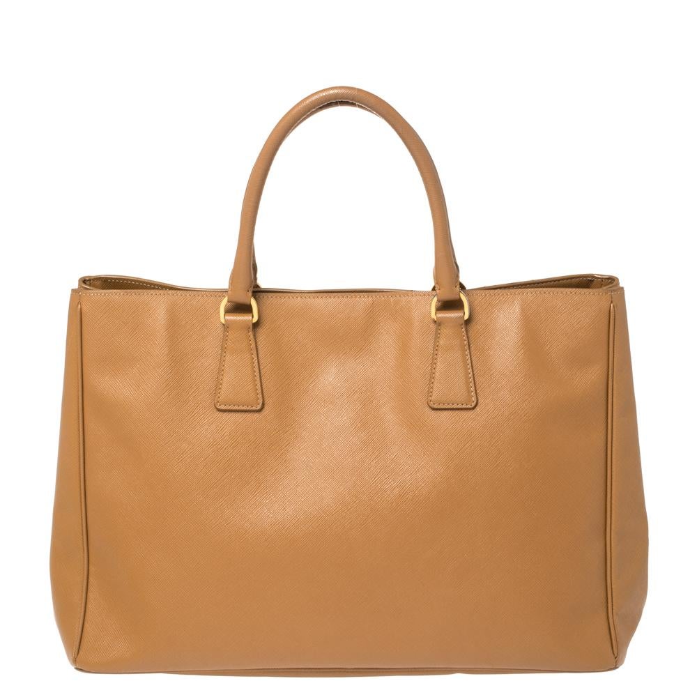 High in appeal and style, this Gardener's tote is a Prada creation. It has been crafted from Saffiano Lux leather and shaped to exude class and luxury. The bag comes with two handles and a spacious nylon interior for your ease. Protective metal feet