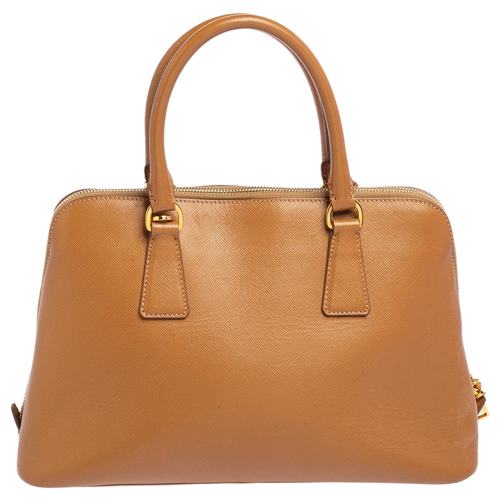 This stunning Promenade satchel is high in appeal and style. Dazzling in a classy tan shade, the bag is crafted from leather and features two rolled handles. The zip closure leads way to a fabric interior with enough space for your essentials and