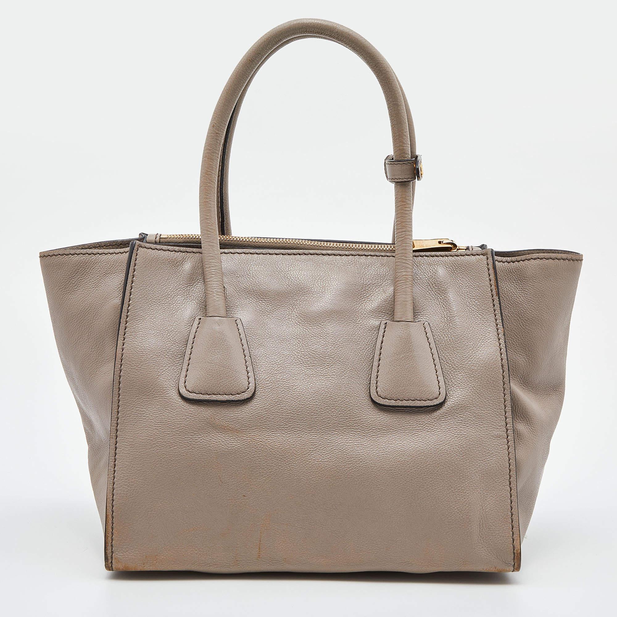 Add some effortless style and luxury to your everyday looks with this stunning Prada tote. Crafted in leather, this bag can store all that you need throughout the day or for work. The bag is equipped with the brand logo on the front, dual handles,