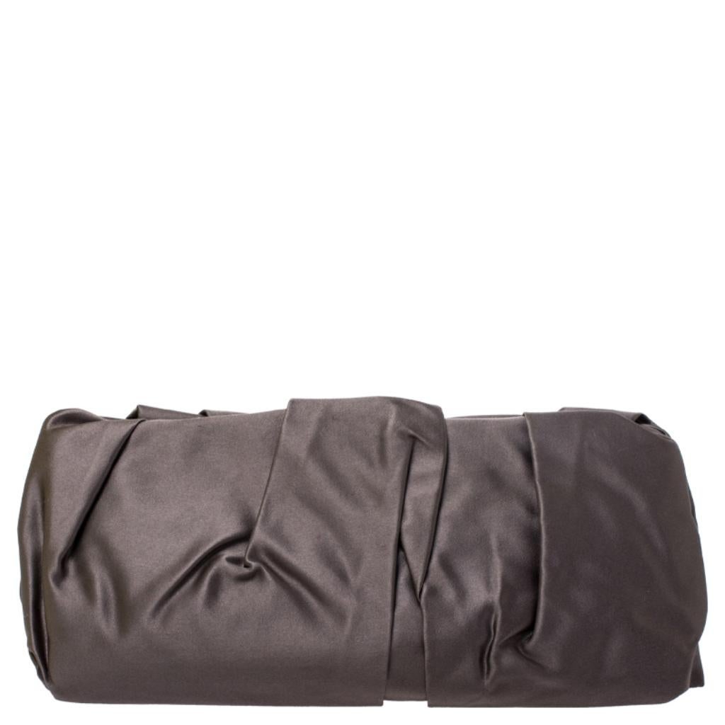 The perfect accessory on a night out, this Prada Raso clutch is elegant and stylish. The pleated satin exterior features brand detailing in gold-tone hardware. This clutch comes with a top push-lock closure that opens up to a satin-lined interior