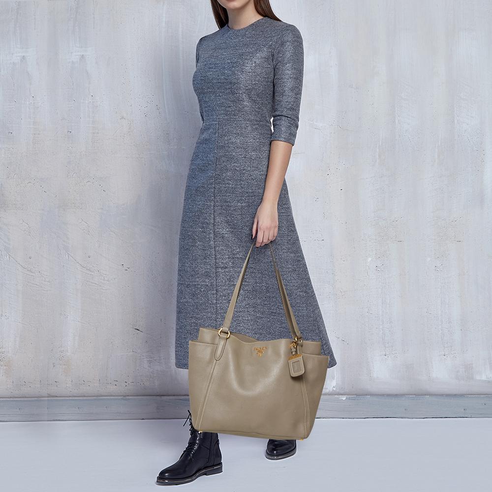 You don’t have to worry about things missing or falling with this Manici shopper tote from Prada. Made from Vitello Daino leather, this tote features two flat handles and the brand detail on the front. The nylon-lined interior is sized to easily