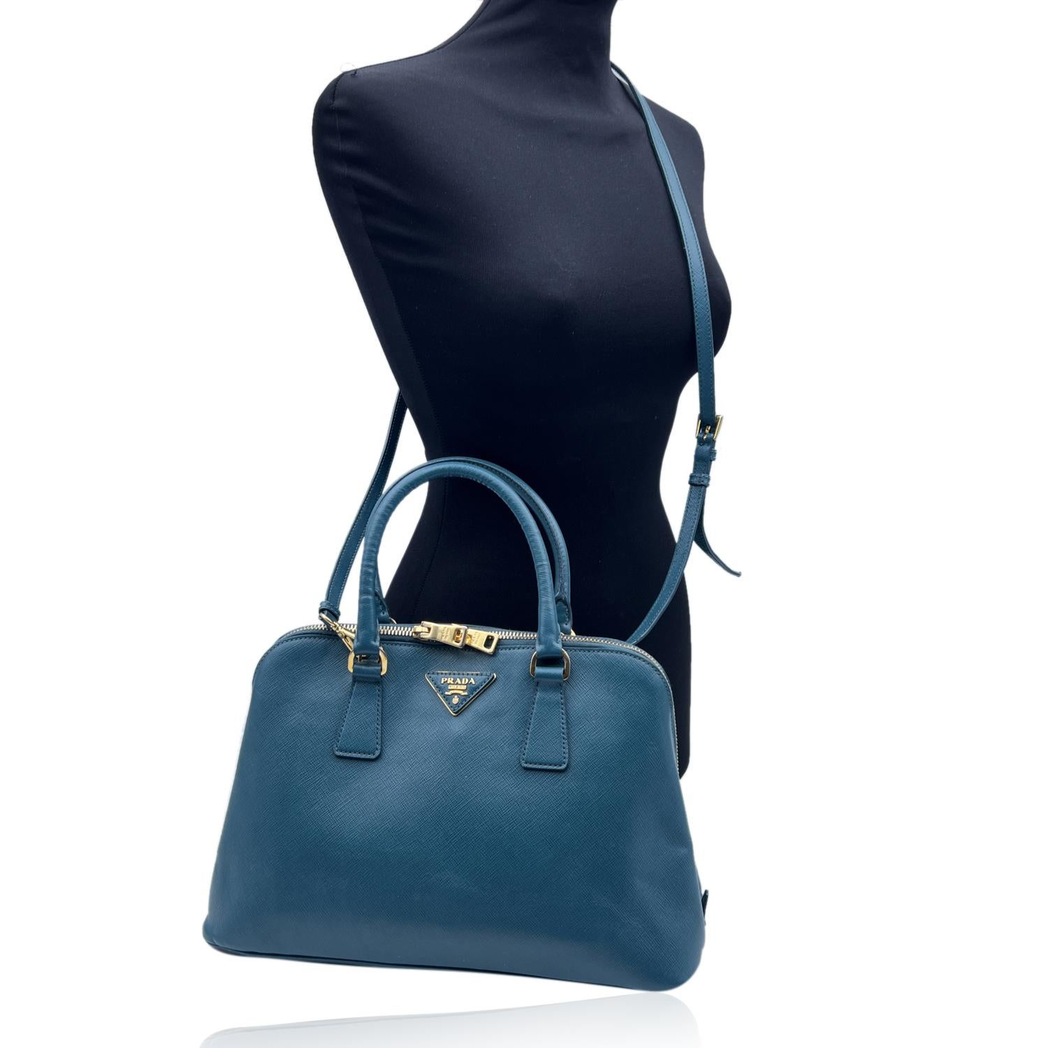 Stunning PRADA top handles bag/handbag mod. 'Promenade', designed in teal Saffiano leather and finished with leather triangle logo on the front. . It features double round top handles and a removable and adjustable shoulder strap . Upper zipper