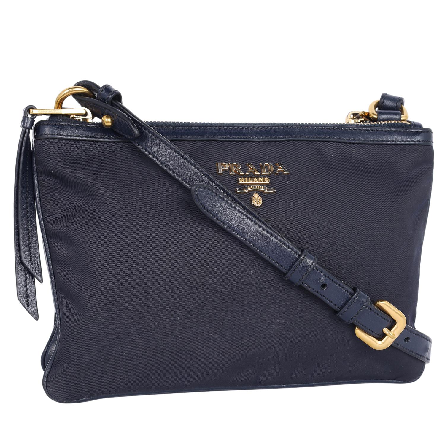 Authentic, pre-loved Prada tessuto nylon blue double zip leather crossbody bag. Features double sided bags with zipper top closure, leather accent, gold tone hardware, long adjustable leather strap, interior with zipper pocket. The dark blue color