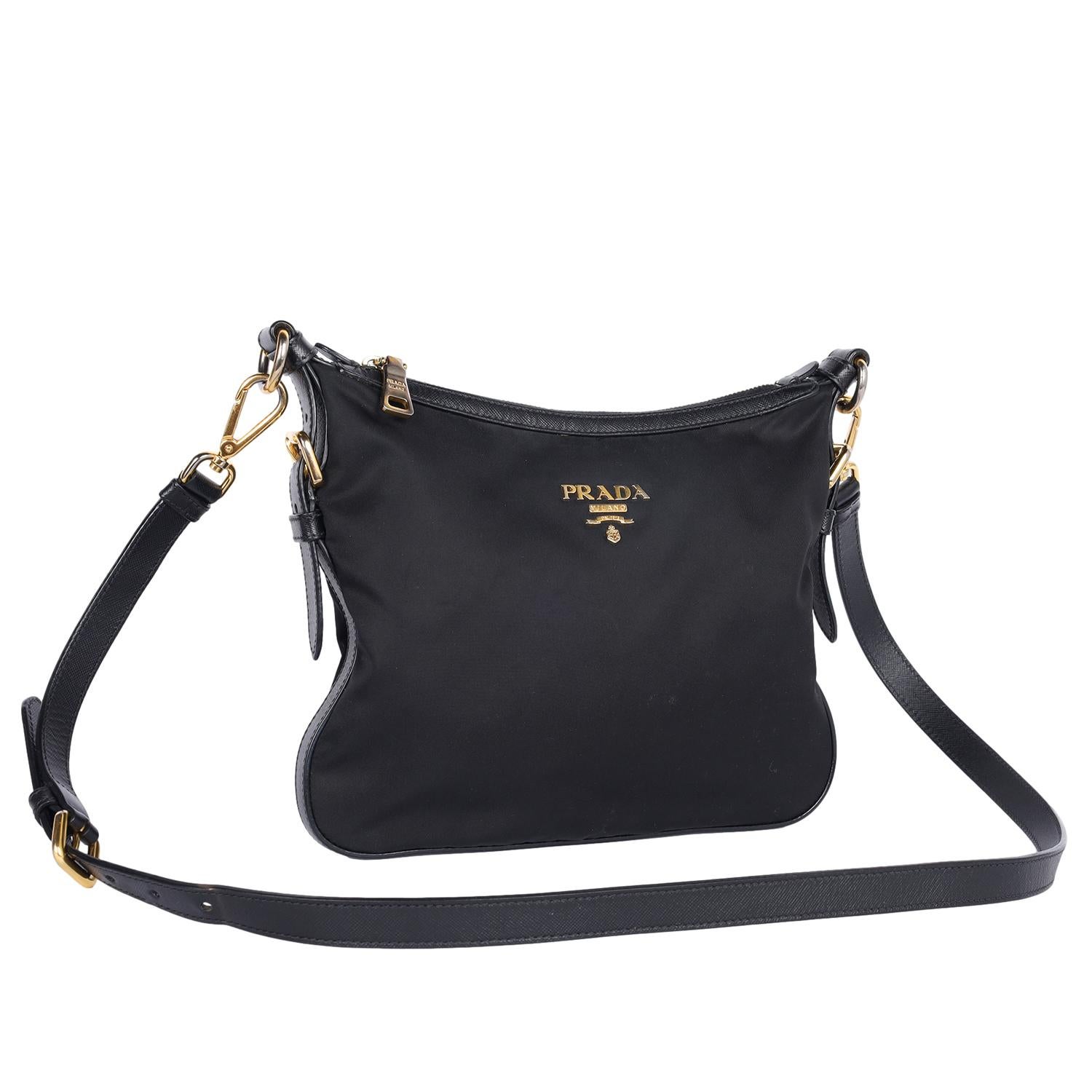 Autentica borsa Prada Tessuto Nylon in nero. Presenta una base in nylon, una lunga tracolla regolabile, una decalcomania Prada sulla parte anteriore della borsa, un ampio e profondo interno con tasca con cerniera, una chiusura superiore con cerniera