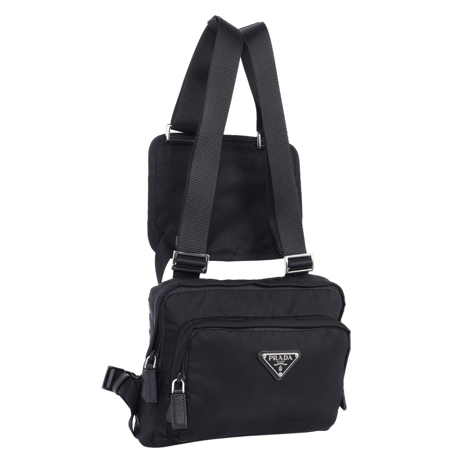 Authentic New Prada Tessuto Nylon Montagna Harness Bag in Black. Features Tessuto nylon in black with leather accents, dual bags with zipper top closures, adjustable shoulder straps with silver hardware. The interior opens to a black nylon fabric