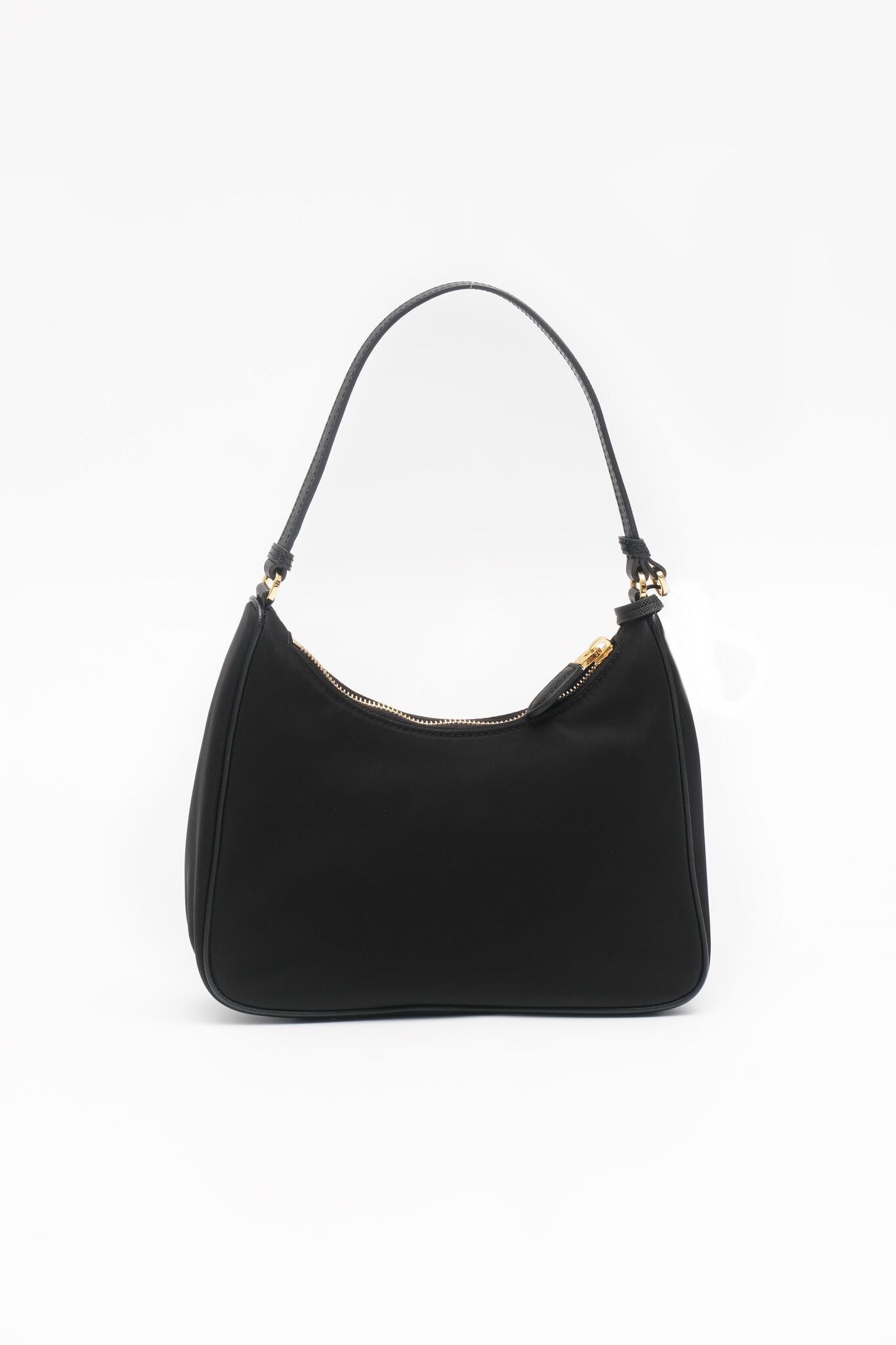PRADA Tessuto Nylon Saffiano Mini Re-Edition 2005 Bag in Black. Crafted from durable black nylon with a black leather shoulder strap and gold zipper. The interior features black jacquard fabric.

Color: Black

Material: Nylon

Comes With: Dust bag