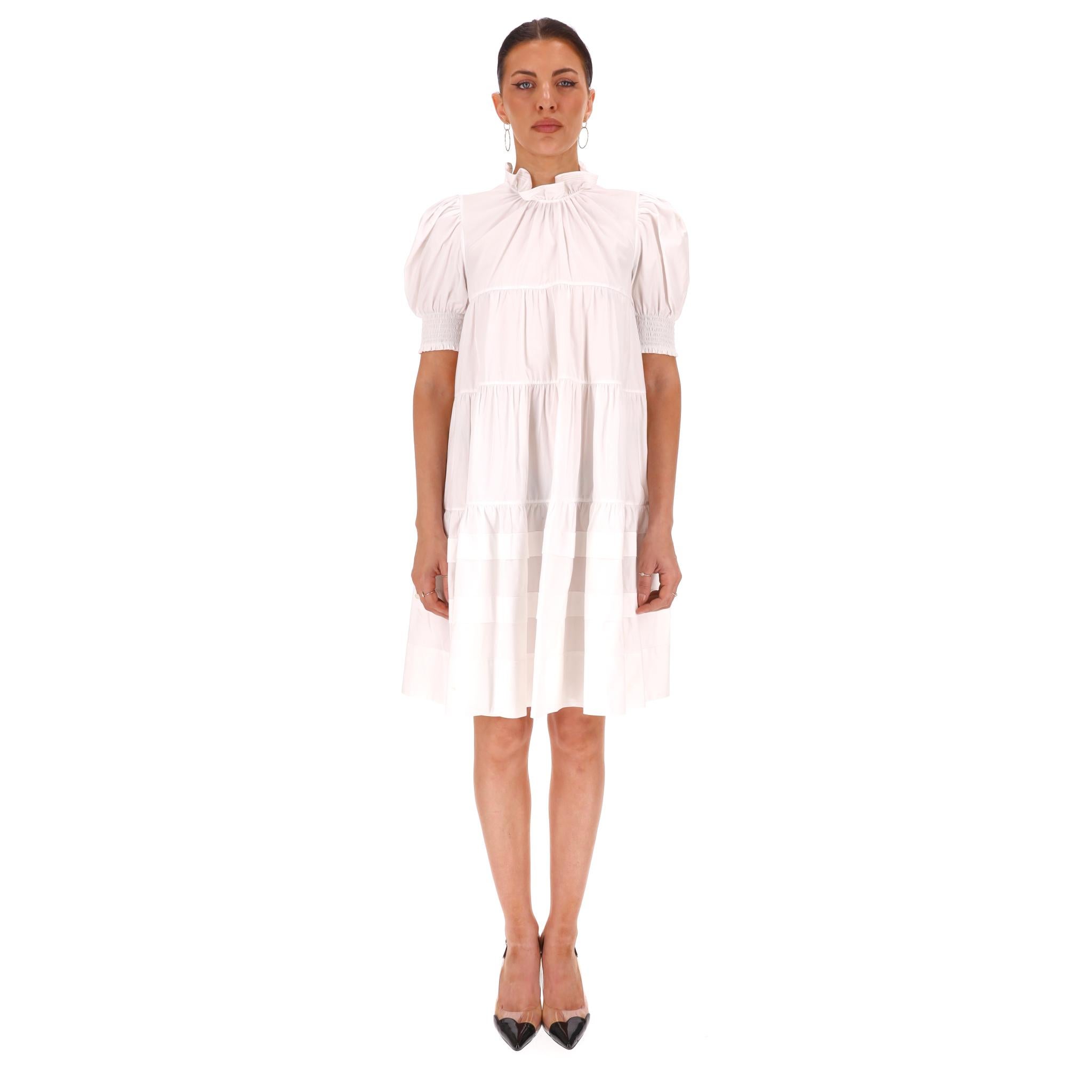 Abito in cotone con maniche a sbuffo a strati di Prada

Abito bianco interamente realizzato in cotone con maniche corte a sbuffo e scollo con volant.

Caratterizzato da un corpetto a strati con una silhouette ampia e chiusura a zip sul