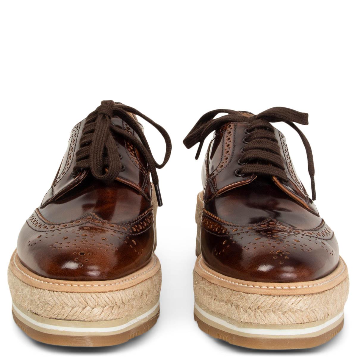 100% authentic Prada platform brogues in brown calfskin with a varnished finish on a beige raffia flat platform sole.  Featuring a braided raffia sole, a lace-up front fastening, a round toe and rubber sole. Brand new.

Measurements
Imprinted