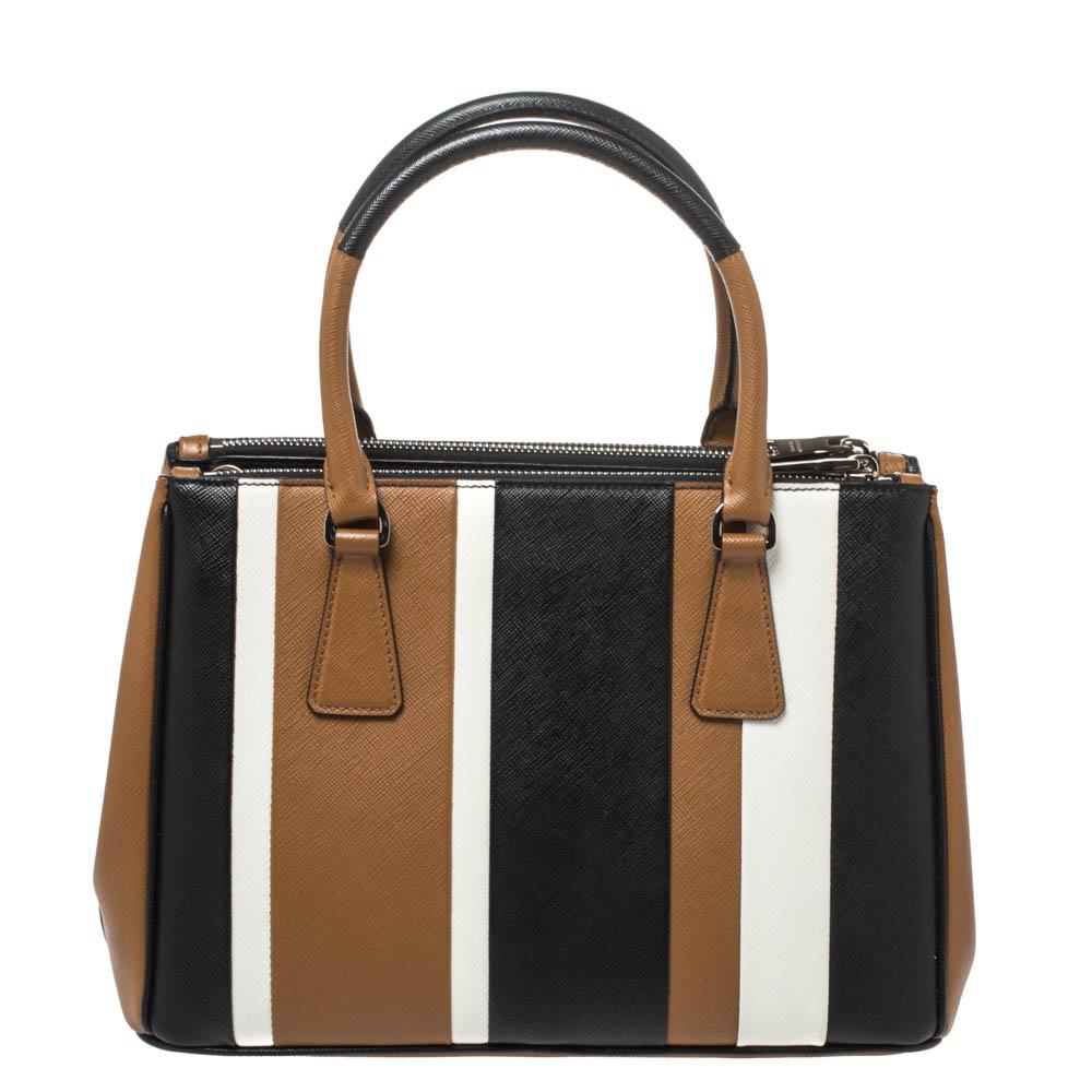Feminine in shape and grand on design, this Double Zip tote by Prada will be a loved addition to your closet. It has been crafted from leather in tricolor stripes and styled minimally with silver-tone hardware. It comes with two top handles, two zip