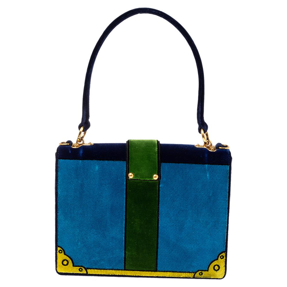 Inspired by valuable books from ancient times, the Cahier by Prada is a coveted accessory. Crafted in Italy, the bag has a tricolor velvet exterior and complementing gold-tone metal accents. The flap with strap and brand details opens to a