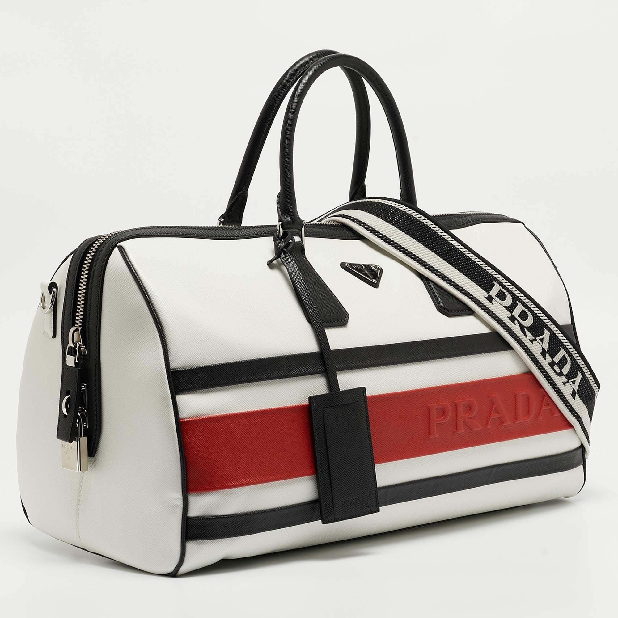 The Prada tavel bag is a luxurious and stylish accessory crafted from high-quality Saffiano leather. Featuring a tricolor design, it blends sophistication with functionality, offering ample storage space for travel essentials. The iconic Prada logo