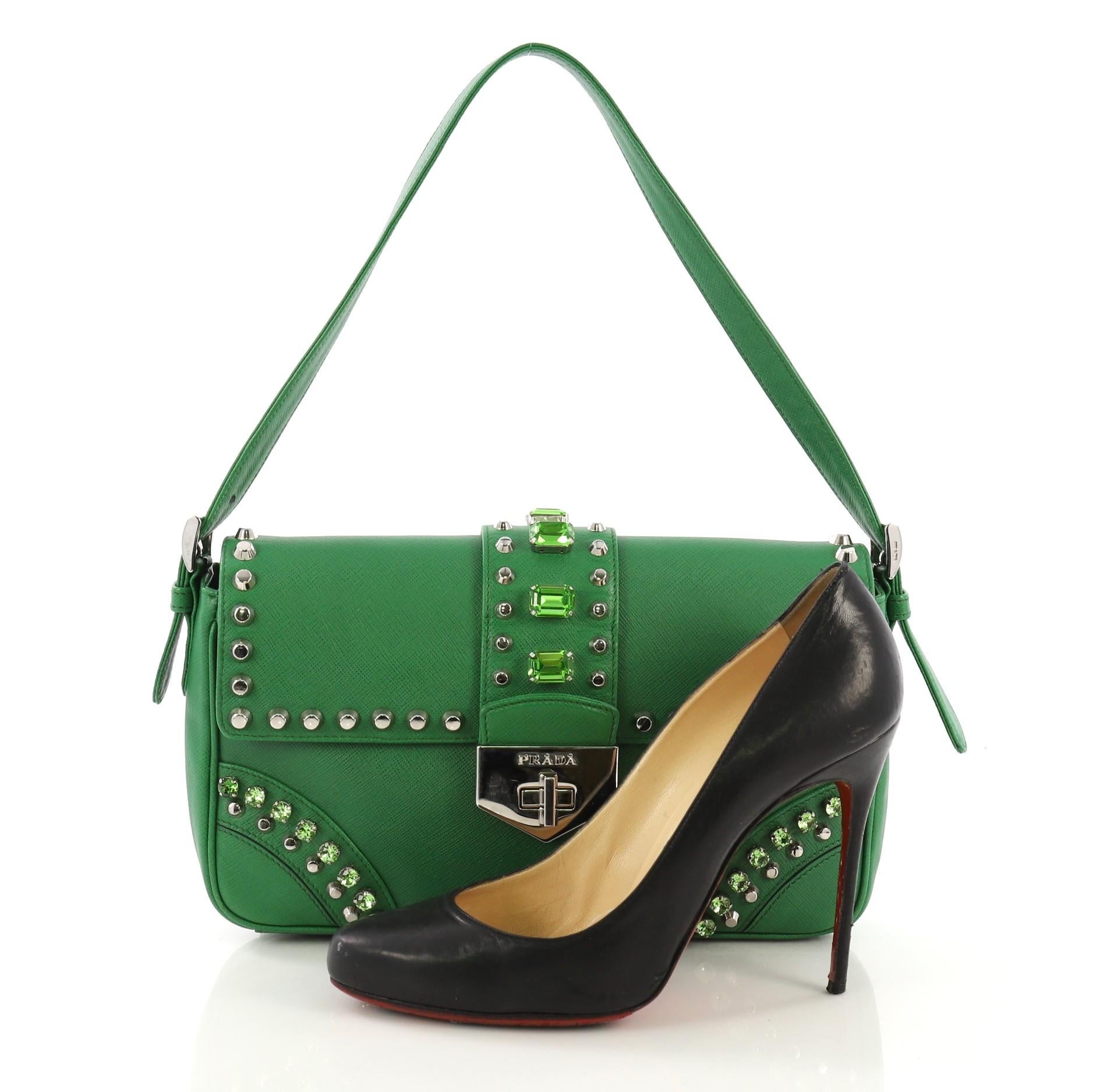 This Prada Turnlock Flap Shoulder Bag Studded Saffiano Leather Medium, crafted from green saffiano leather, features a short adjustable leather handle, diamond and studs detailing, flap with center turn-lock tab closure and silver-tone hardware. Its