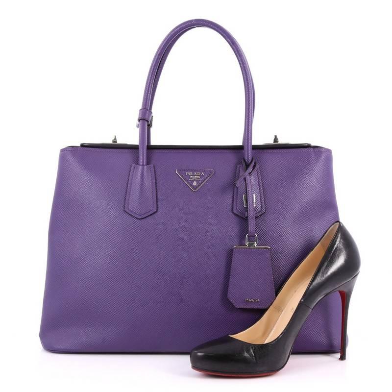 This authentic Prada Turnlock Twin Tote Saffiano Leather Medium is perfect to carry around everyday . Crafted from purple saffiano leather, this tote features dual-rolled leather handles, angular silhouette, inverted triangle Prada logo, side snap