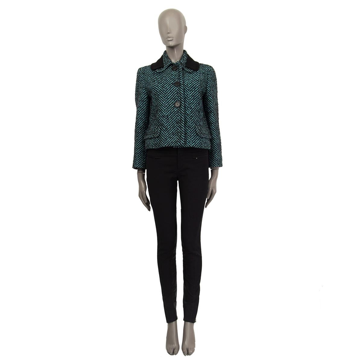 100% authentic Prada cropped tweed jacket in black, turquoise and grey boucle virgin wool (66%) mohair (18%) polyamide (16%) with double layered collar, herringbone tweed , two flap pockets, 3/4 sleeve length with buttoned cuffs in the back. Lined